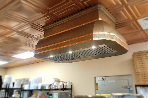 Commercial-style copper range hood with built-in lights and baffle filters.