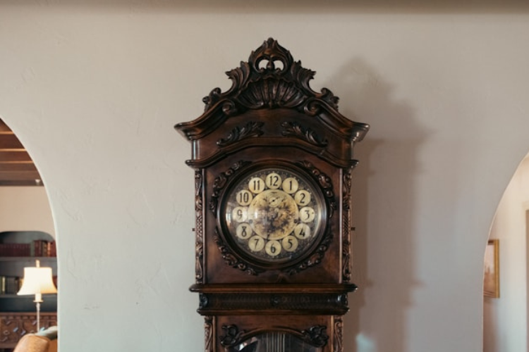 Vintage pendulum wall clock featuring a decorative wooden case and classic dial.