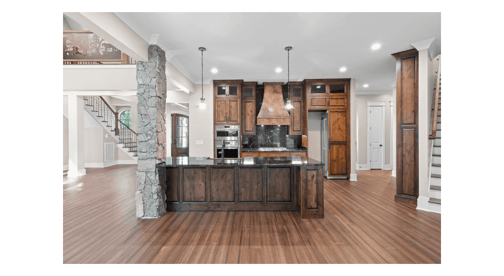 Spacious modern kitchen with wooden cabinets, island, and stone accents.