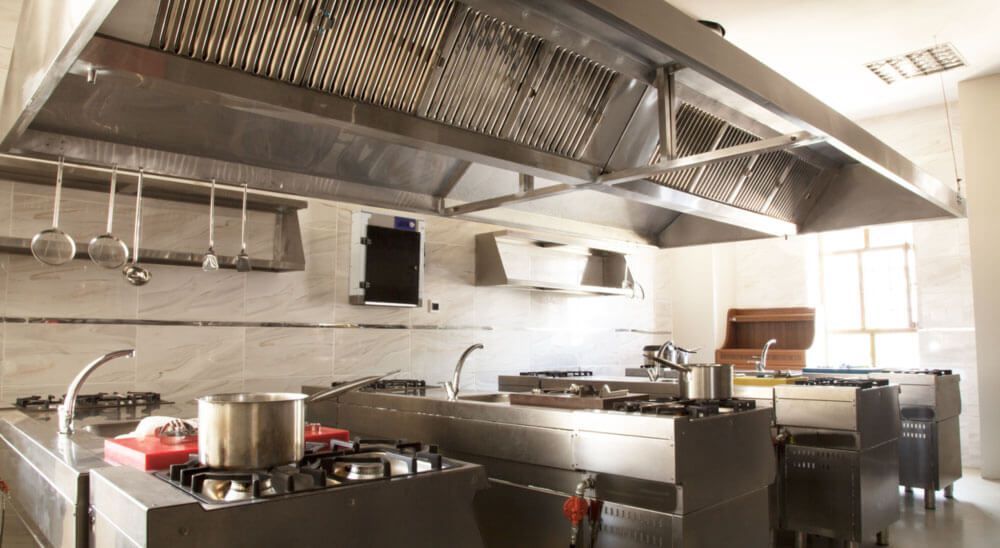 How often should commercial kitchen hoods be cleaned?