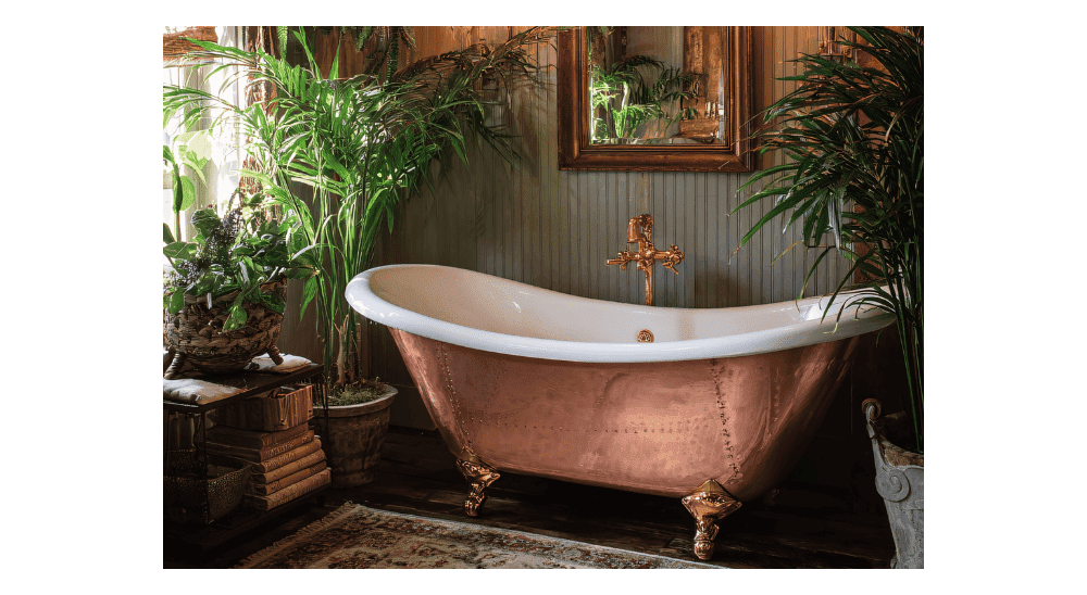 Luxury bathroom featuring a copper clawfoot bathtub surrounded by lush plants.