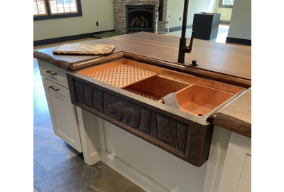 Modern black kitchen sink with running water, minimalist faucet, and natural countertop decor.