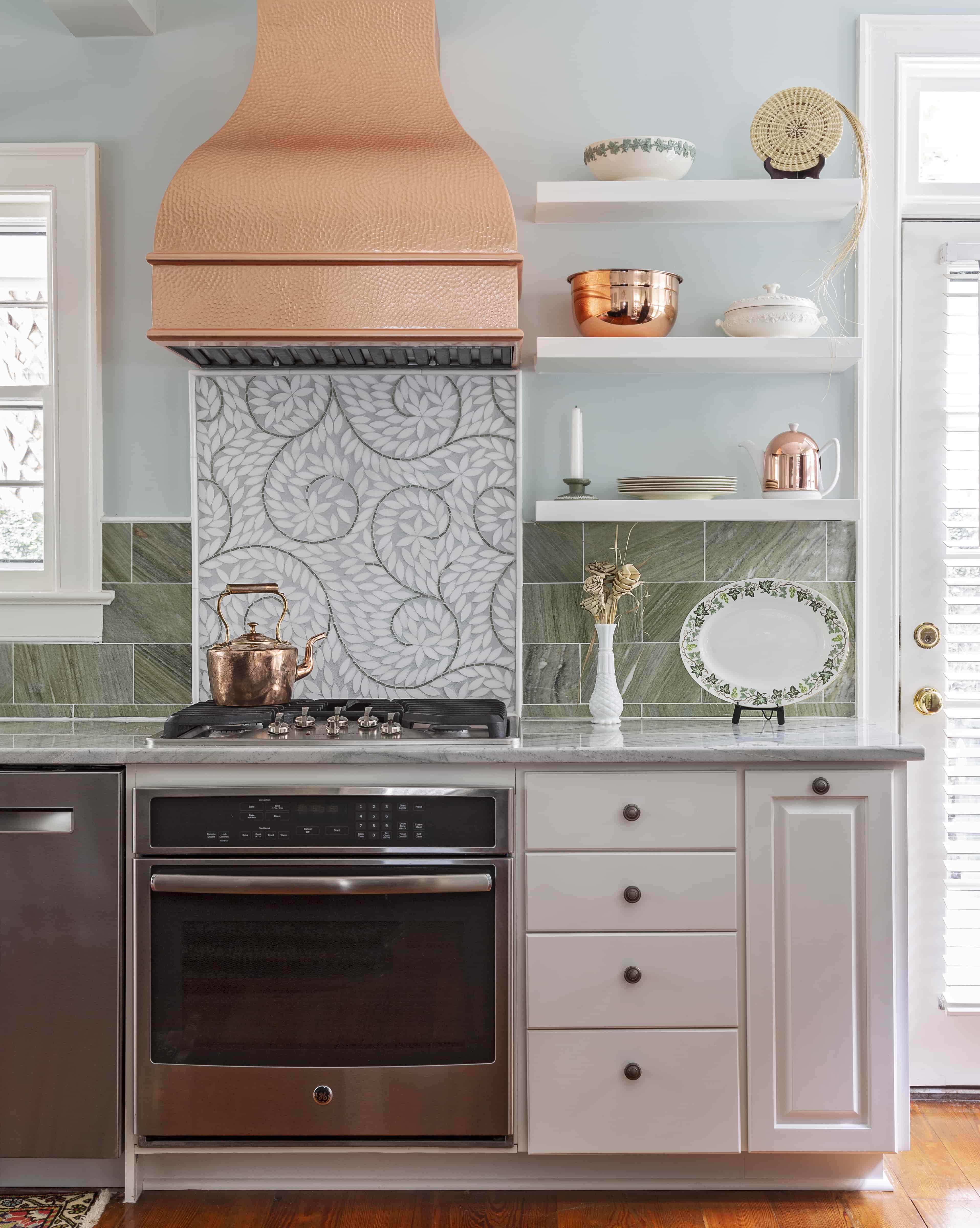 CopperSmith Artisan AT2 Wall Mount Copper Range Hood Antique Beehive Hammered in a coastal style kitchen with marble countertops white tile backsplash and white cabinetry
