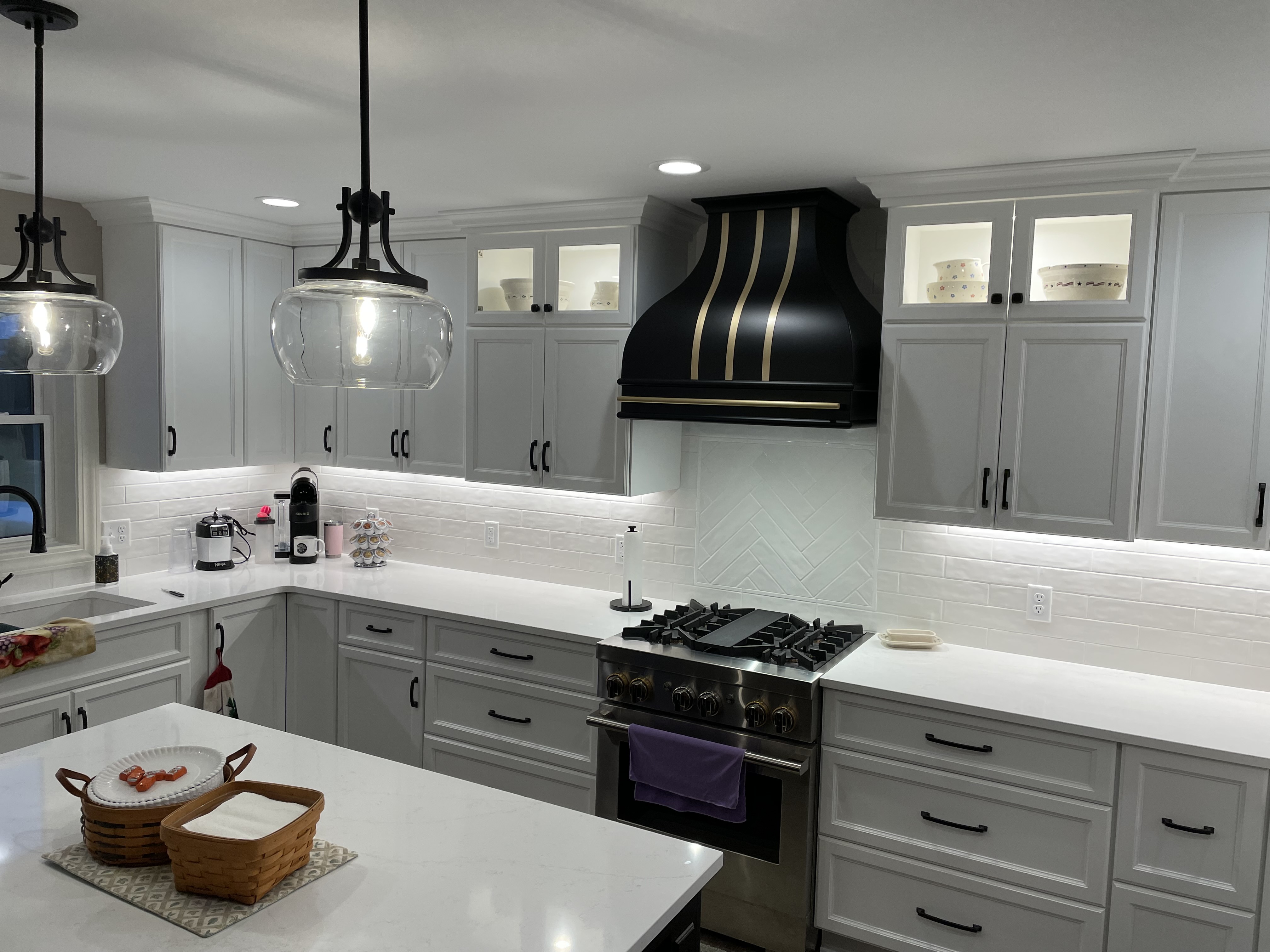Sleek range hood concepts, craftsman-inspired aesthetics, white kitchen cabinets, marble kitchen countertops, captivating brick backsplash