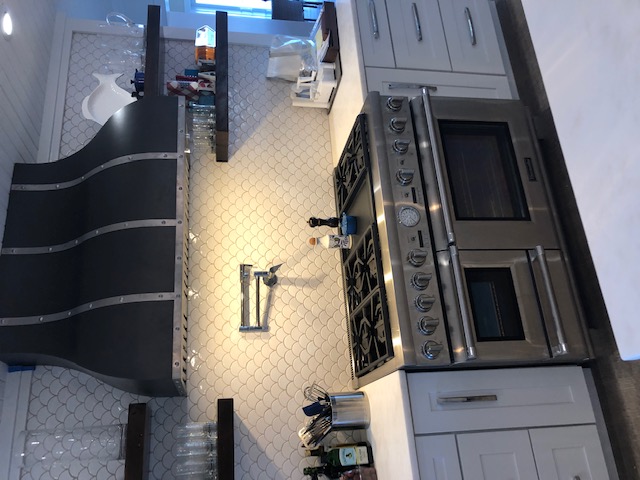 A black and silver metallic range hood in a modern kitchen 