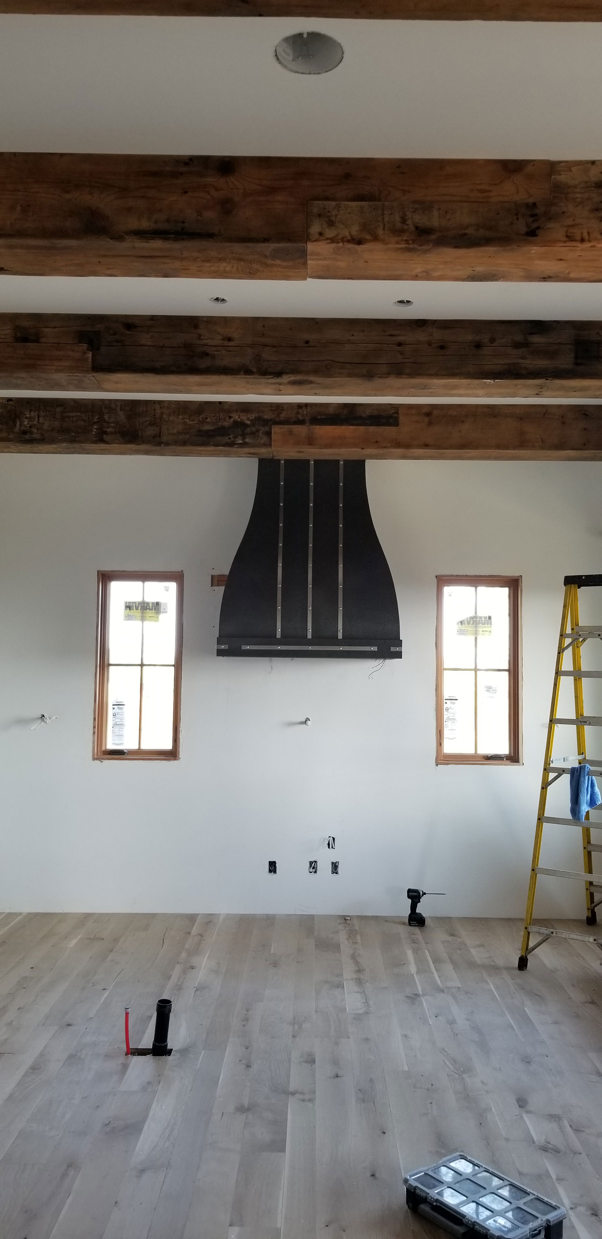 Black range hood with copper accents in remodeled kitchen World CopperSmith