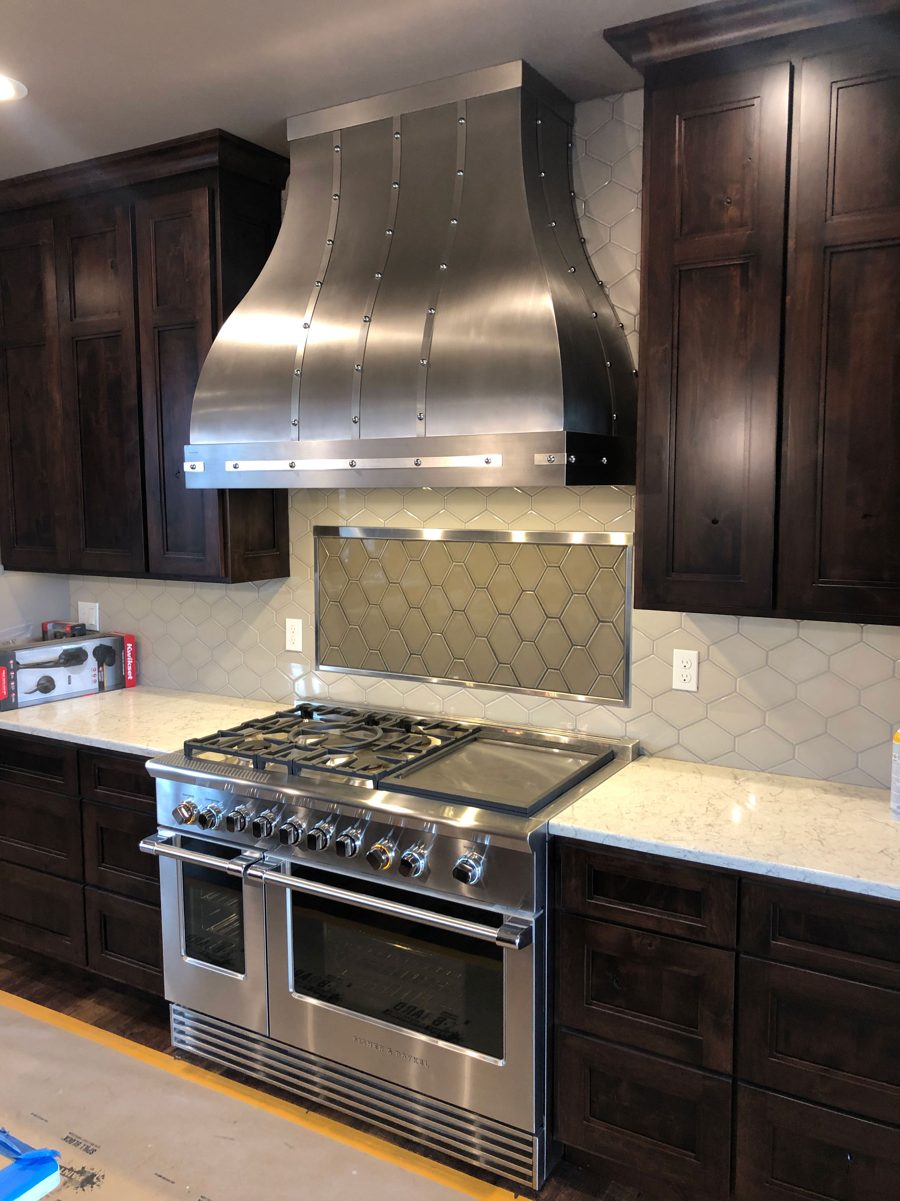 The trendy kitchen design idea is to incorporate a french-inspired theme with, range-hood-idea, complemented by luxurious marble kitchen countertops