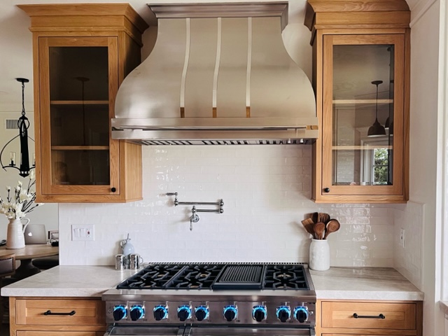 Glamoras range hood, craftsman kitchen concepts, brown kitchen cabinets, exquisite marble kitchen countertops, stunning brick backsplash