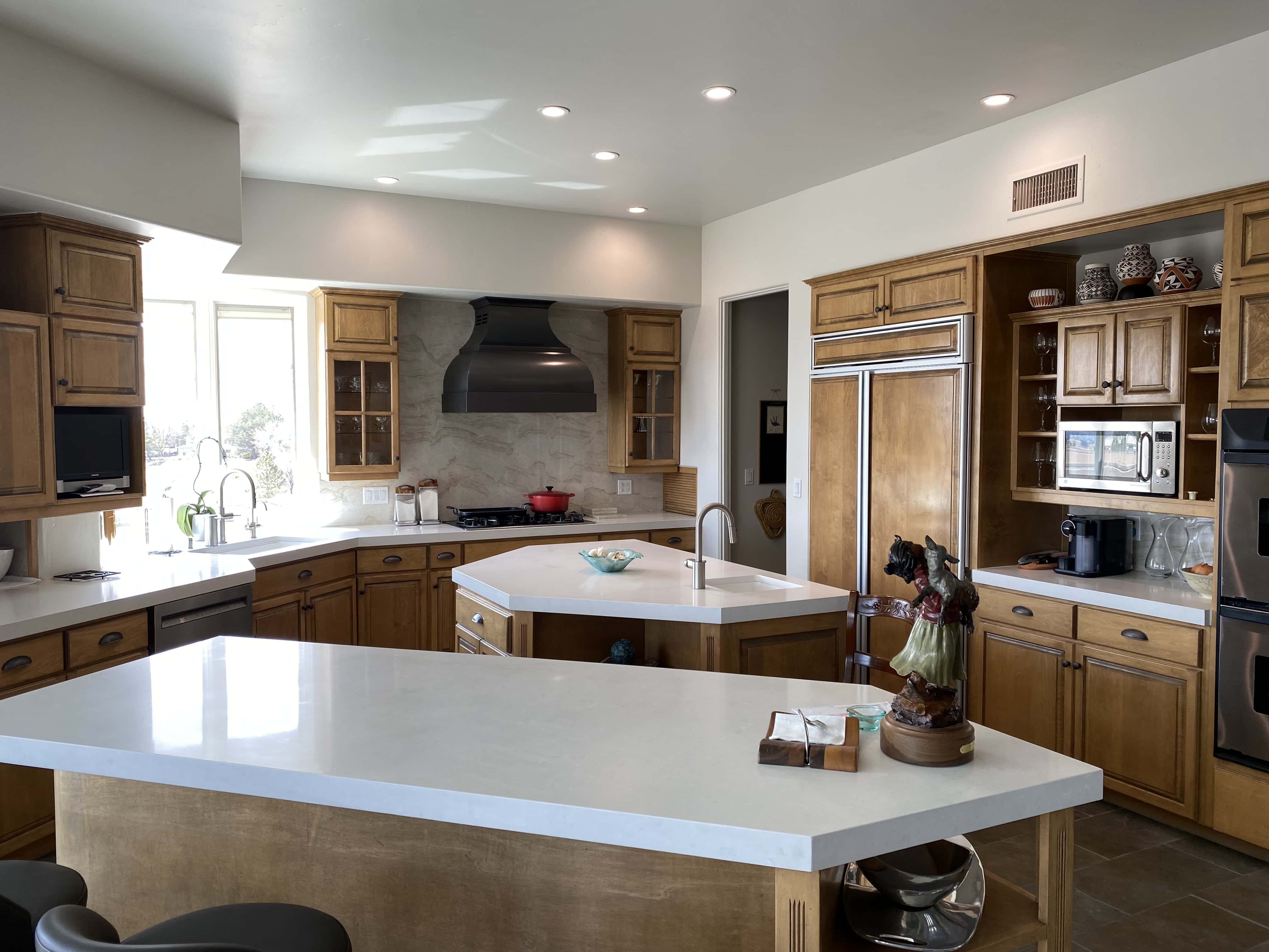 Stunning range hood, rich brown kitchen cabinets, complemented by pristine white kitchen countertops luxurious marble backsplash