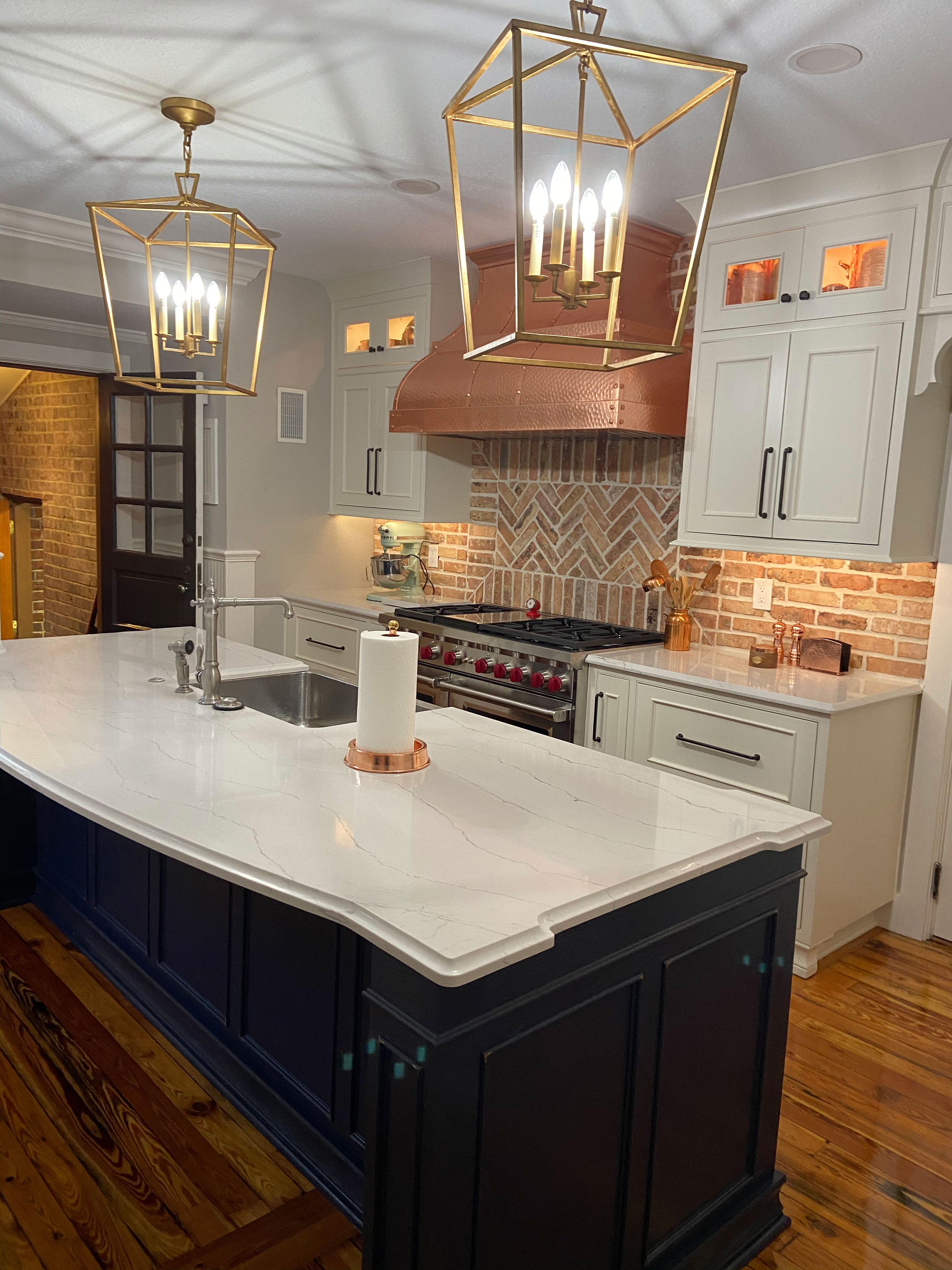 Stylish copper range hood stunning contemporary kitchen remodeling,incorporating white kitchen cabinets, marble kitchen countertops and brick backsplash