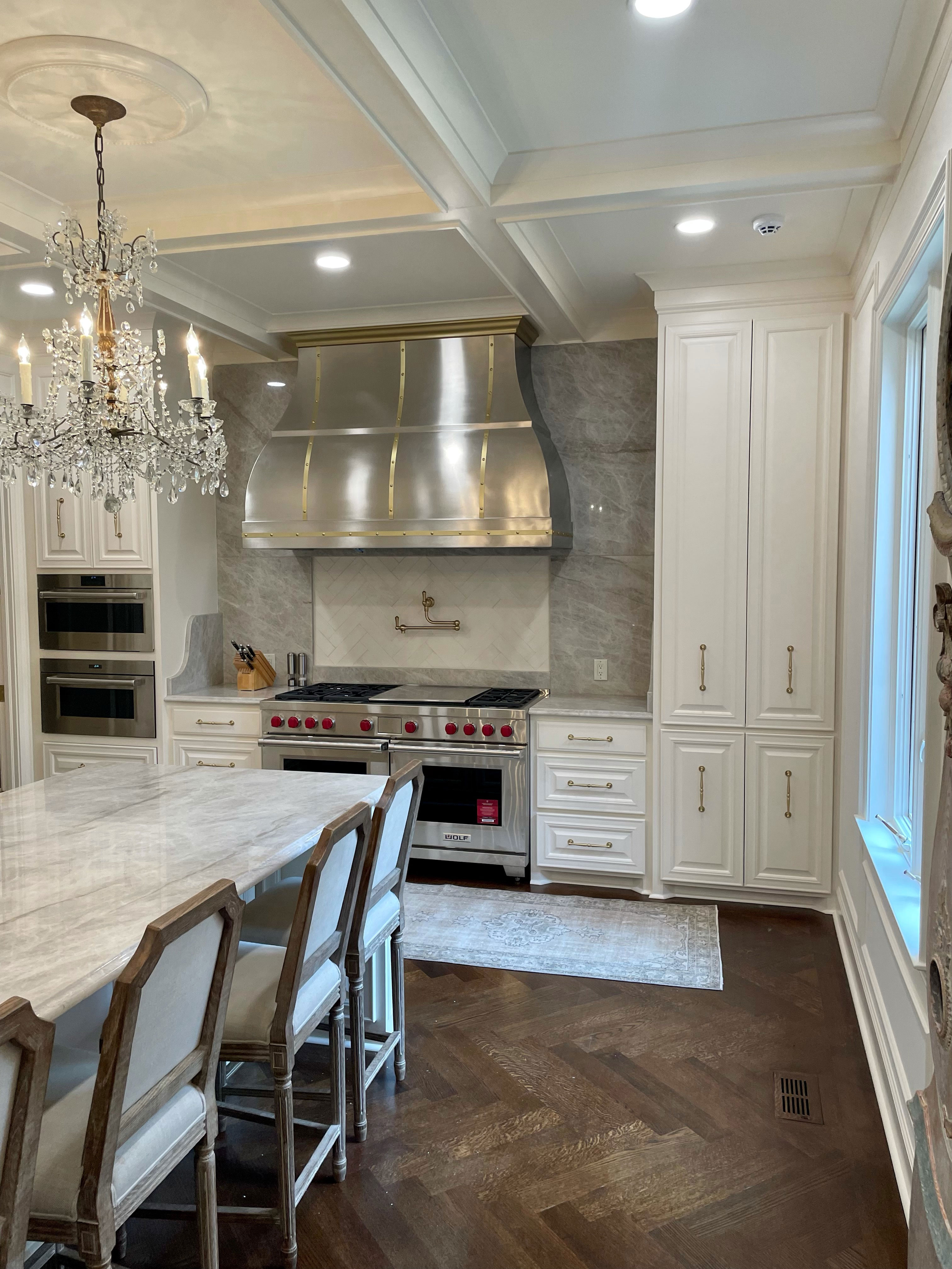 Beautiful kitchen design,incorporating stainless steel range hood with french-inspired kitchen design opting for white kitchen cabinets