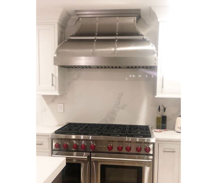 Range hood complemented with a classic kitchen design, consider incorporating white kitchen cabinets with marble kitchen countertops and marble backsplash