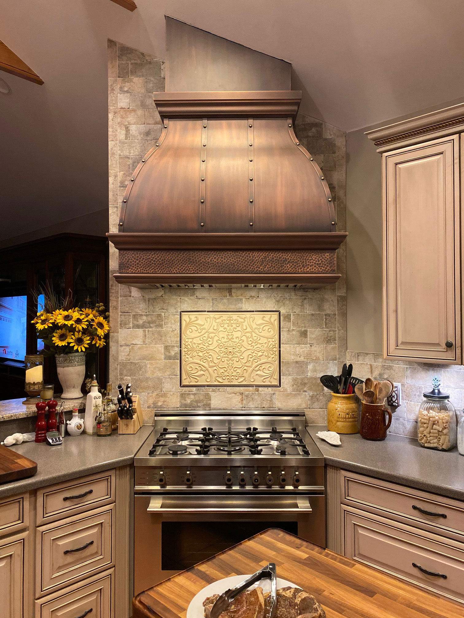 Latest kitchen design idea incorporates a sleek copper range hood, complementing the contemporary kitchen remodeling with its modern aesthetics