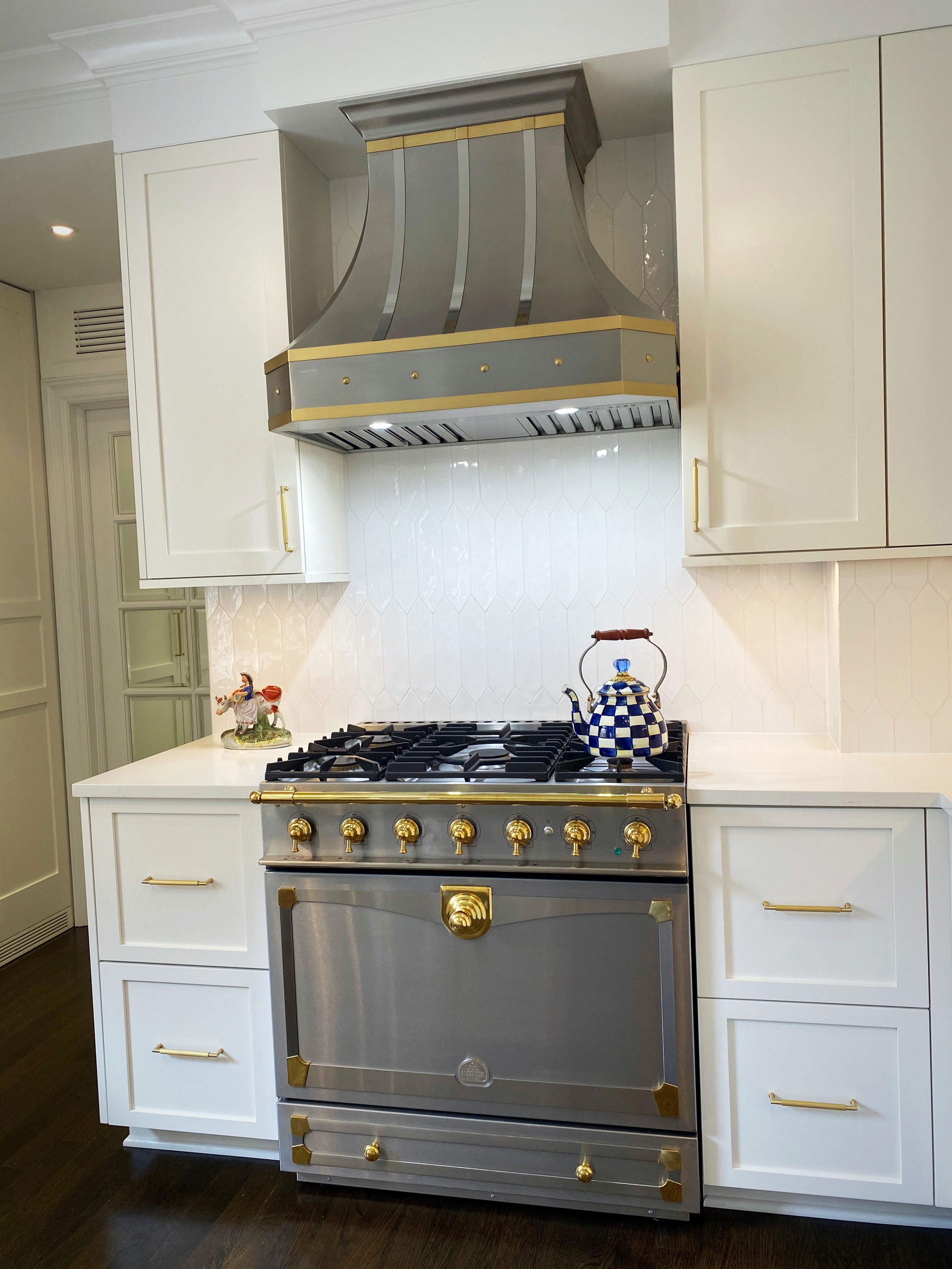 French kitchen design with white cabinets with marble kitchen countertop stylish brick backsplash with range hood