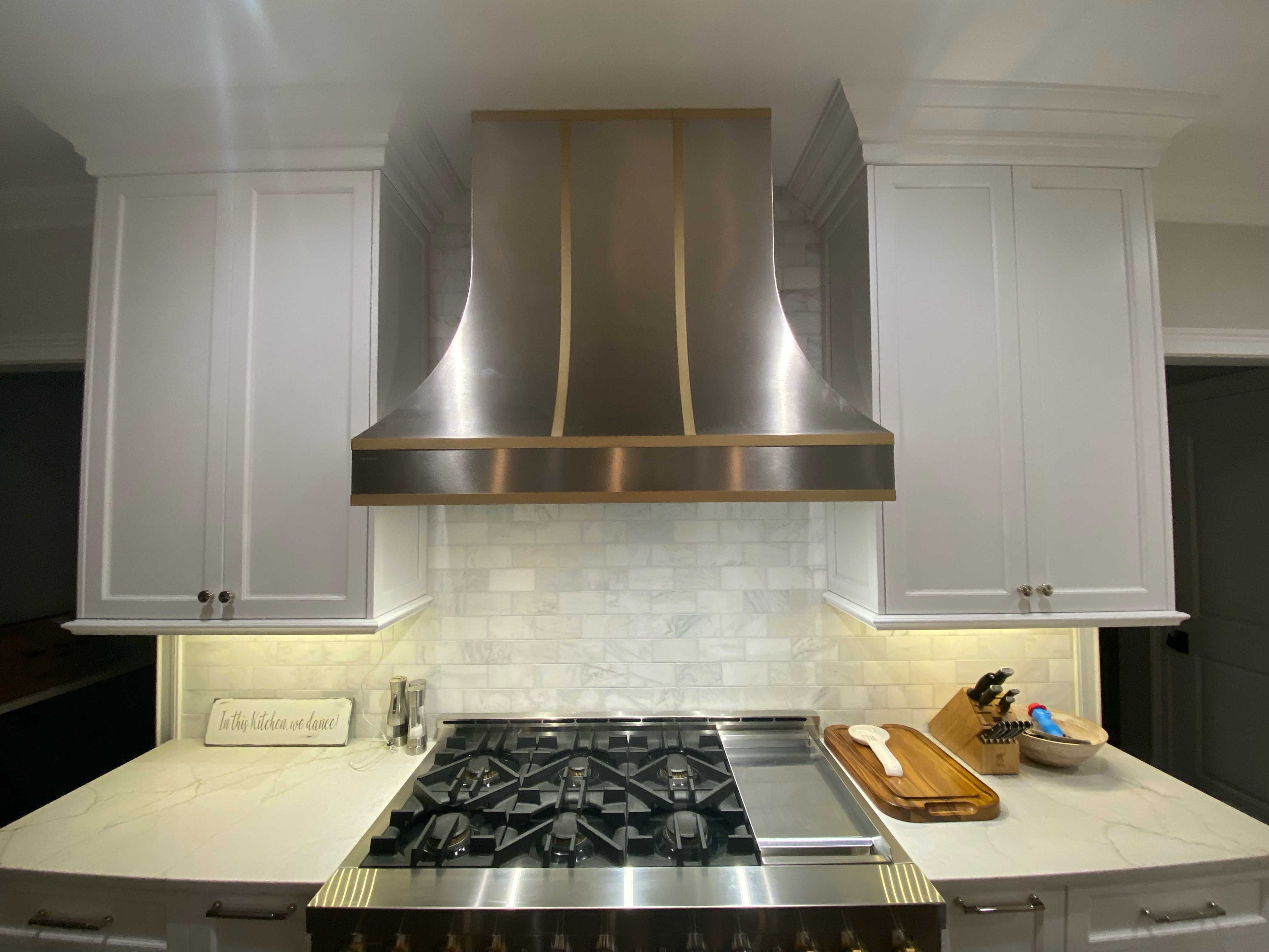 Range hood that complements the overall aesthetic kitchen design idea white kitchen cabinets, white kitchen countertops,marble backsplash