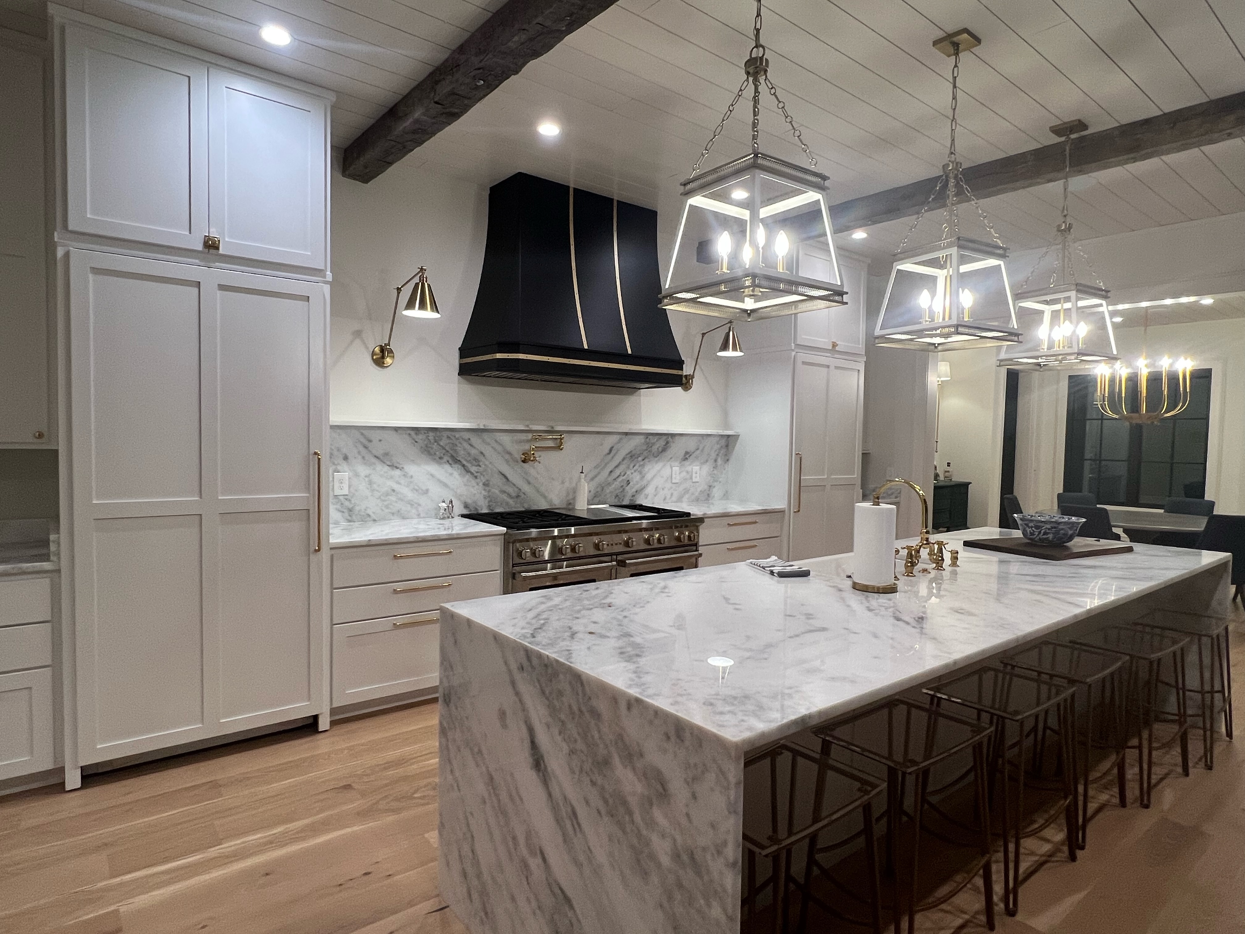 Incorporate a sleek marble backsplash with white kitchen cabinets stainless steel range hood for a coastal-inspired kitchen design
