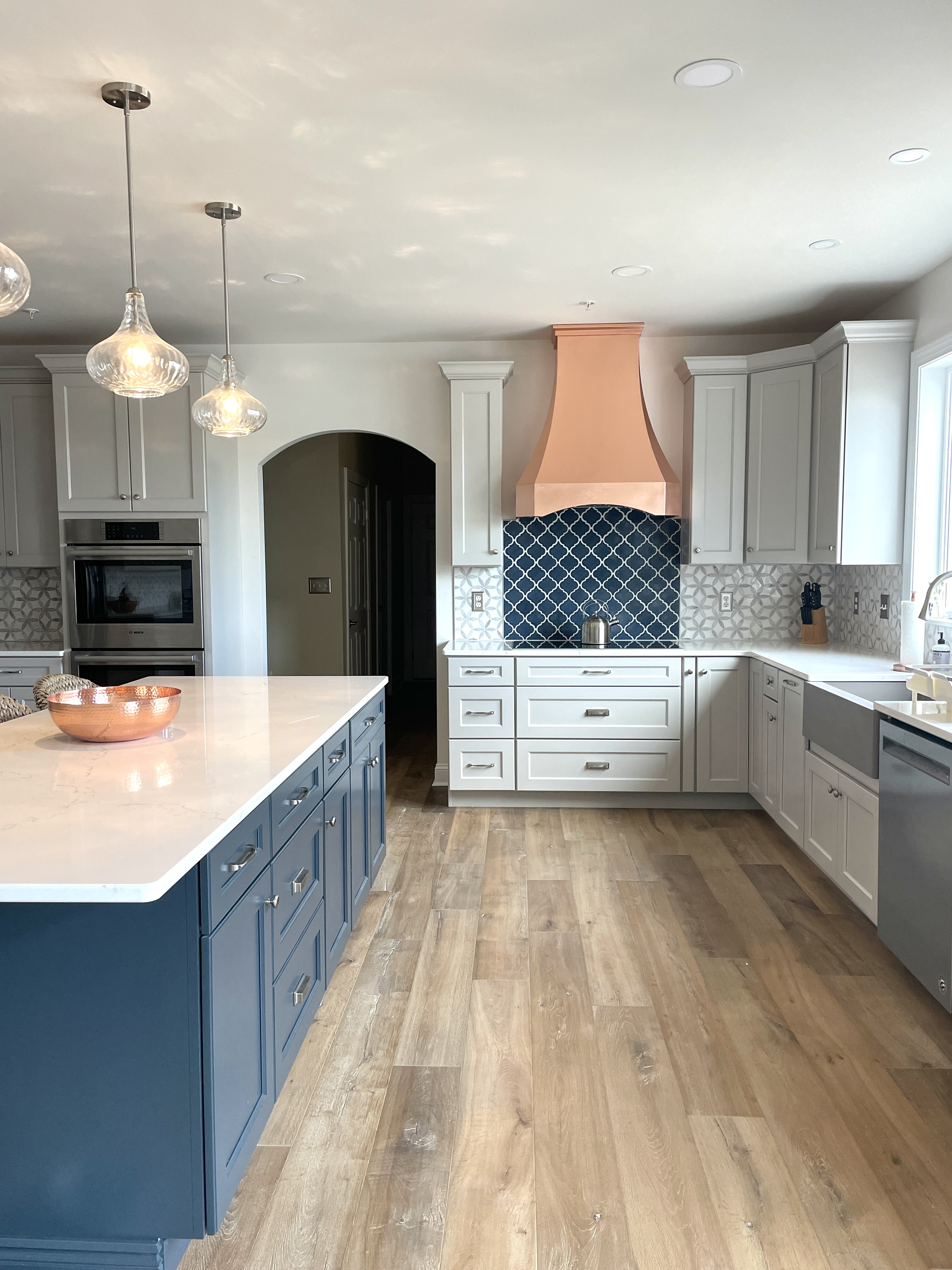 Featuring french inspired elements range hood options, kitchen design idea, white kitchen cabinets, white kitchen countertops, luxurious marble backsplash