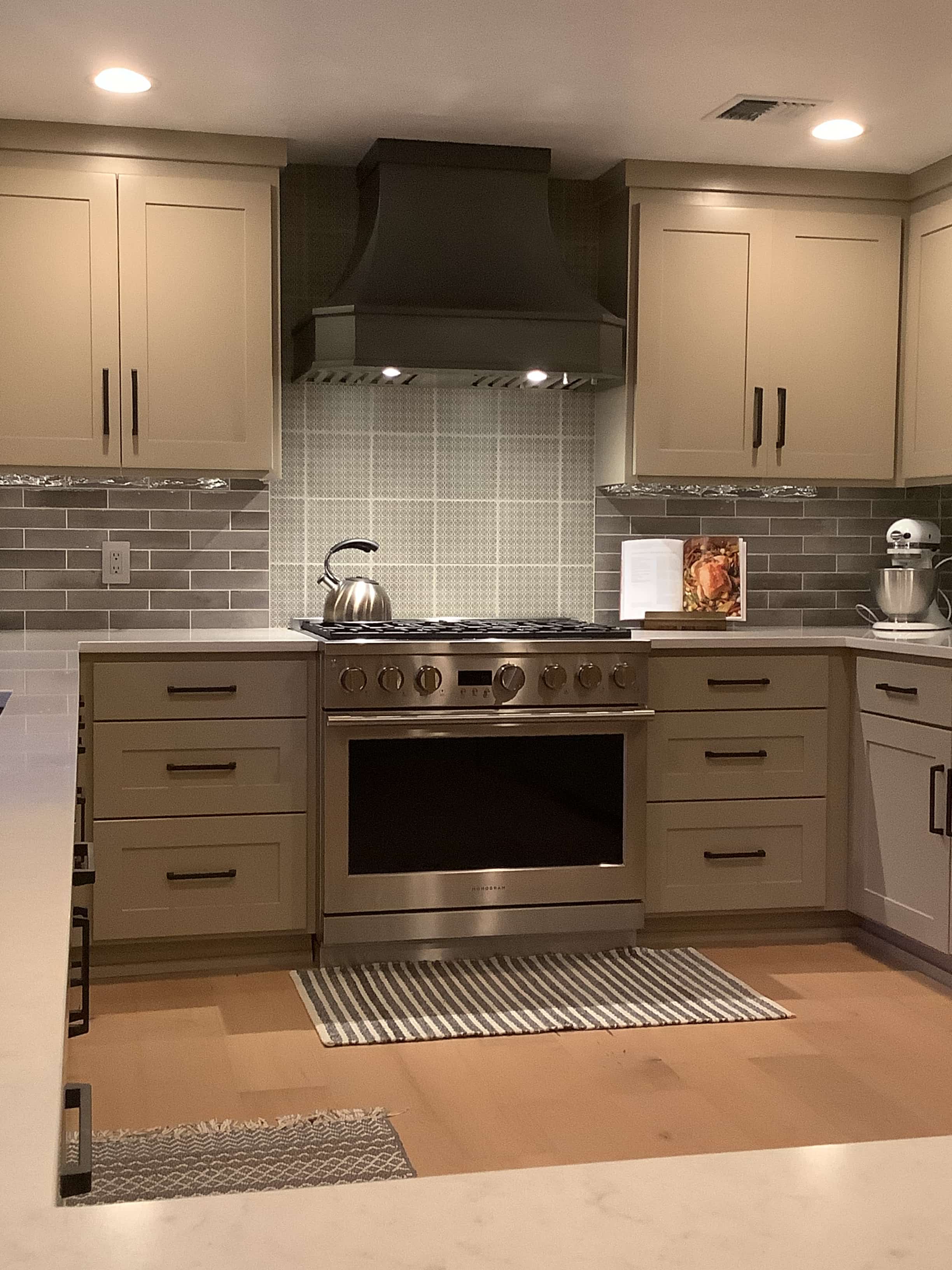 French inspiration meets modern elegance, enhance the ambiance with sleek grey kitchen cabinets complete the look with a charming brick backsplash
