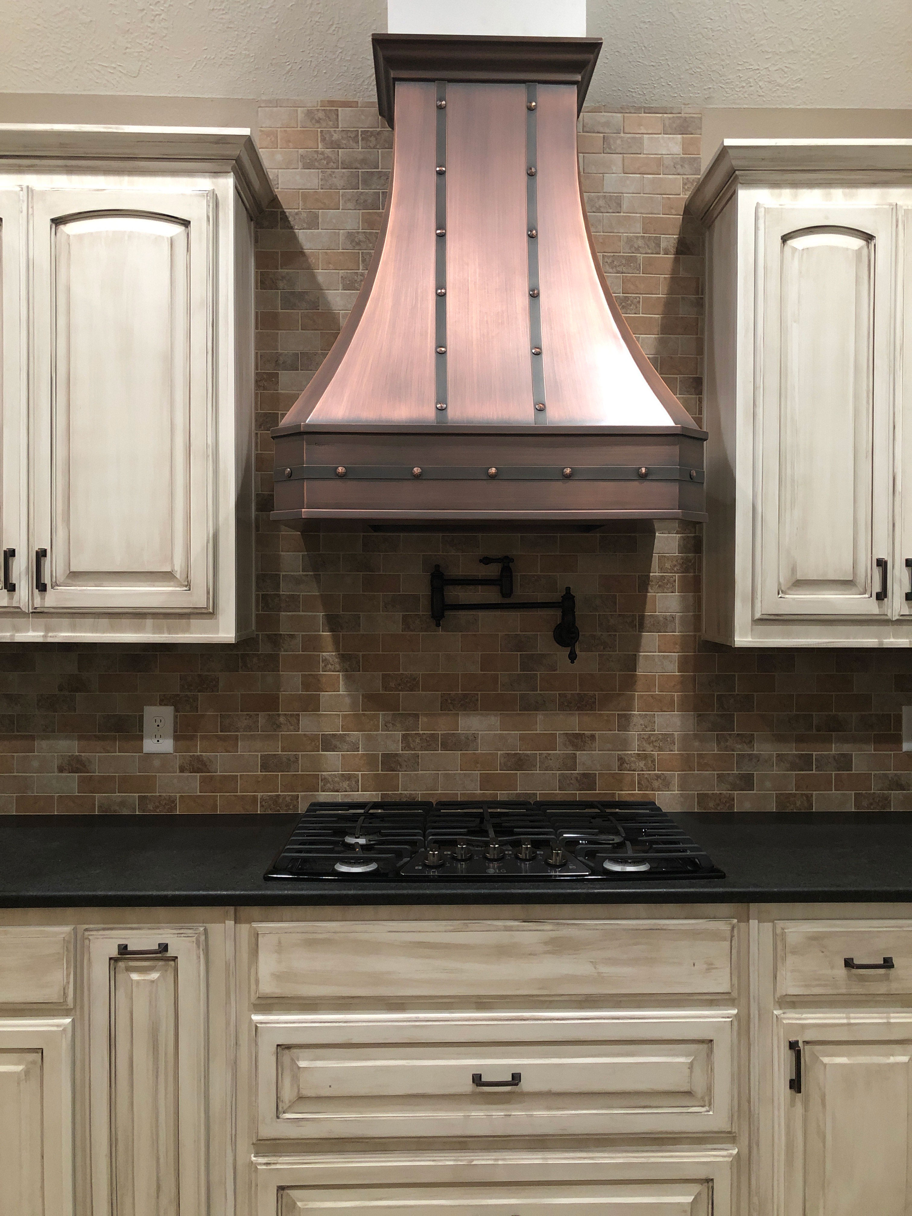 Stunning kitchen design with, range hood, white kitchen cabinets,white kitchen countertops with brick backsplash