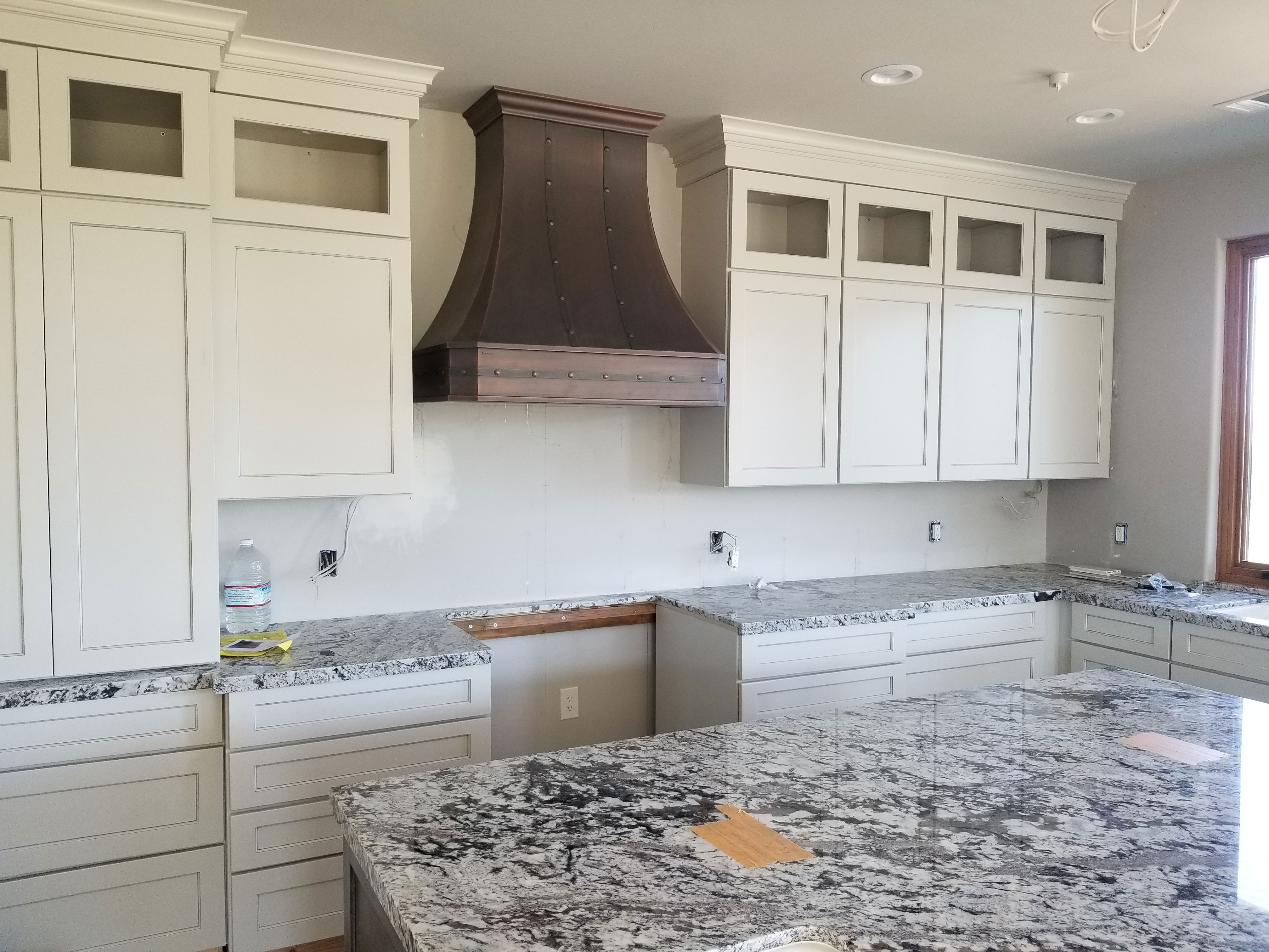 Exquisite kitchen design with range hood, white kitchen cabinets,marble kitchen countertops,captivating marble backsplash