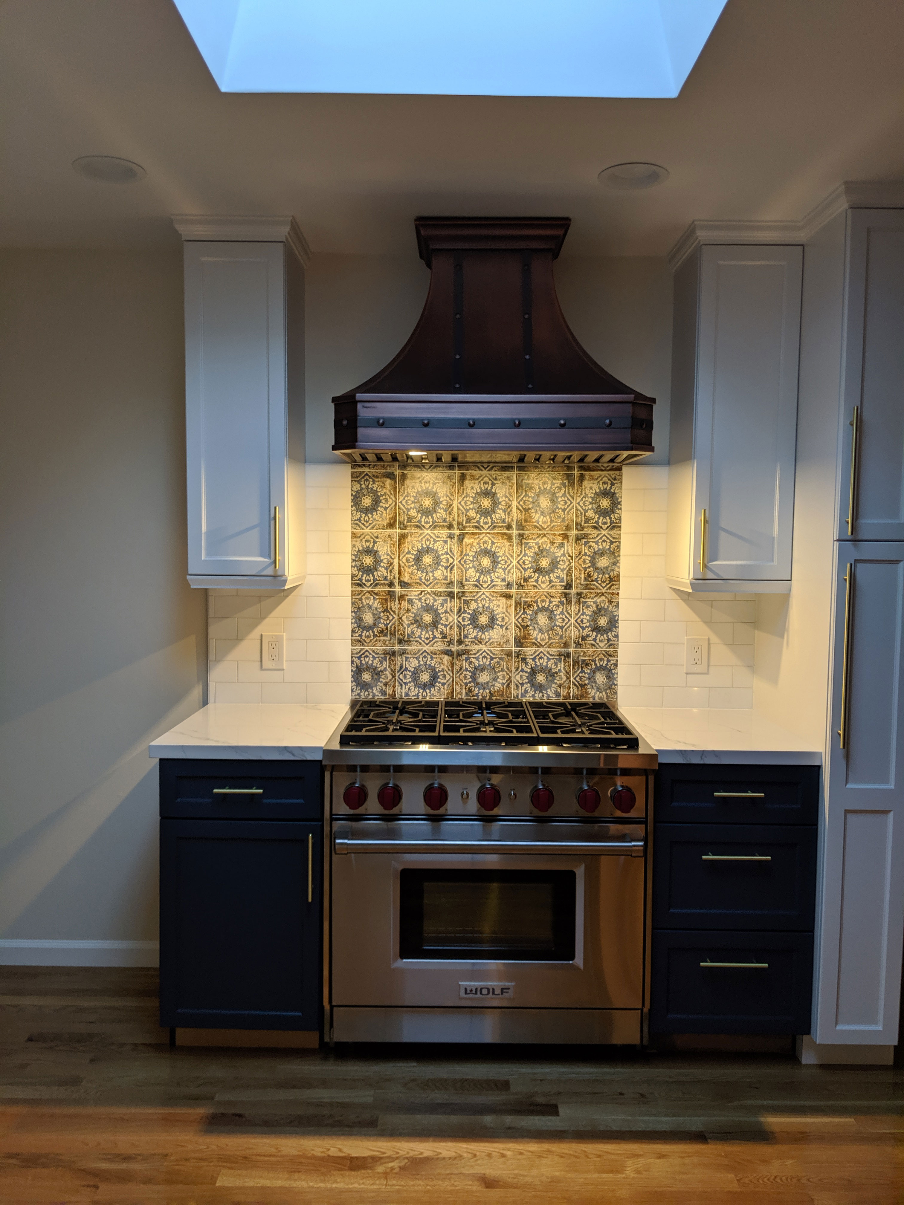 Cottage kitchen design with, inspiring range hood , blue cabinets,marble countertops, stunning marble backsplash