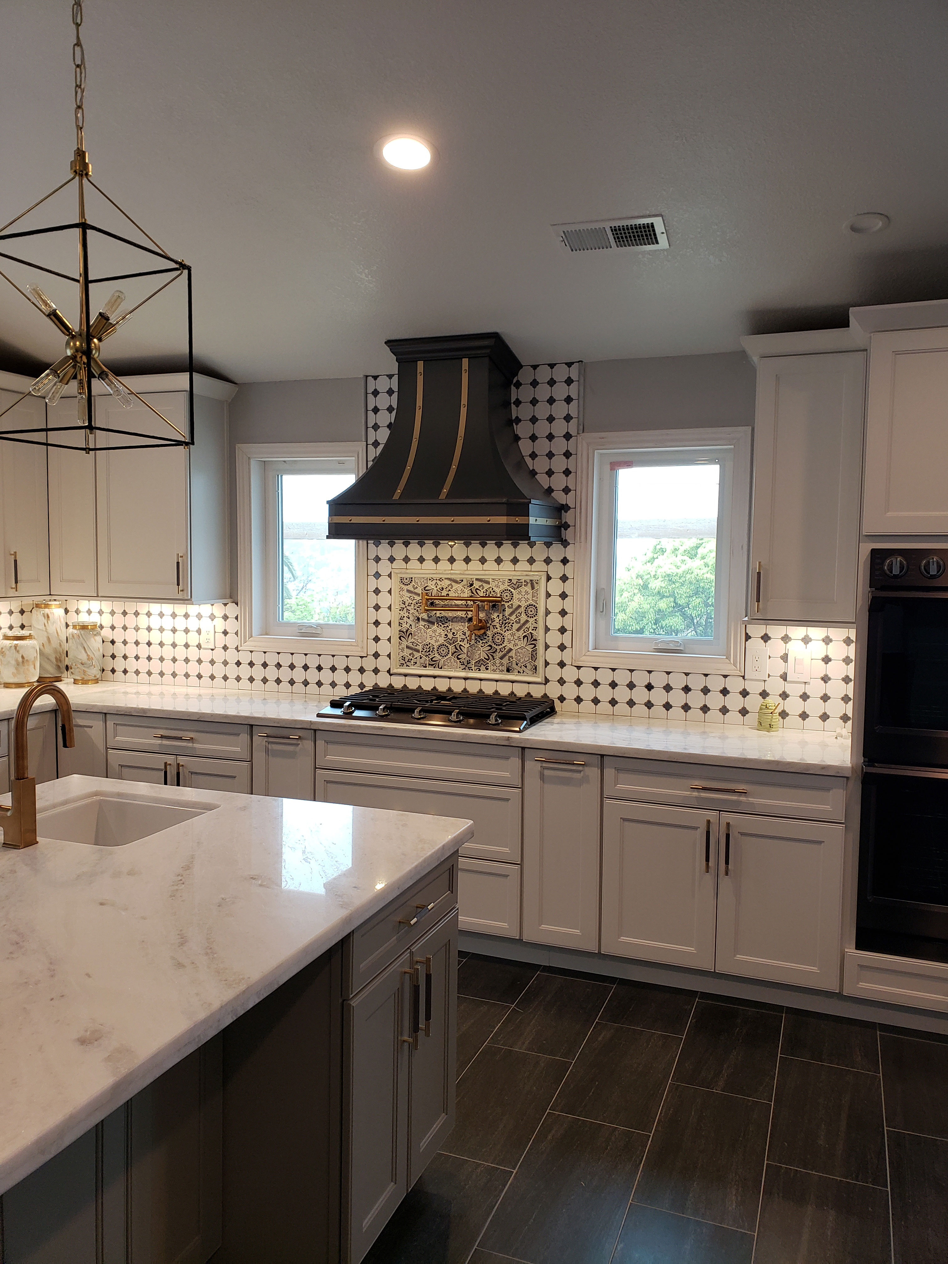 Enchanting kitchen design idea,white cabinets, marble countertops, stunning marble backsplash with range hood
