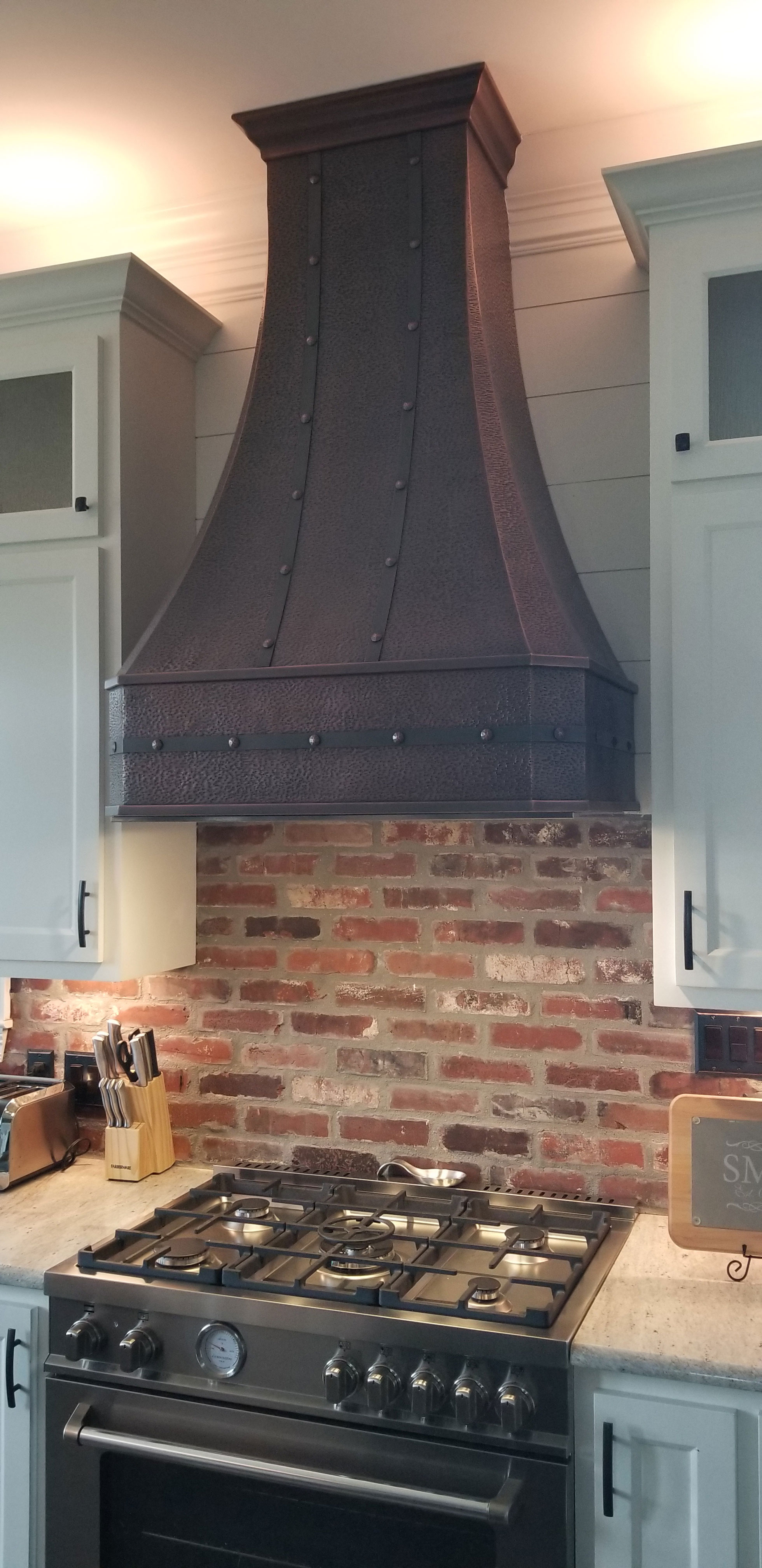 Narrow copper range hood with brick wall World CopperSmith