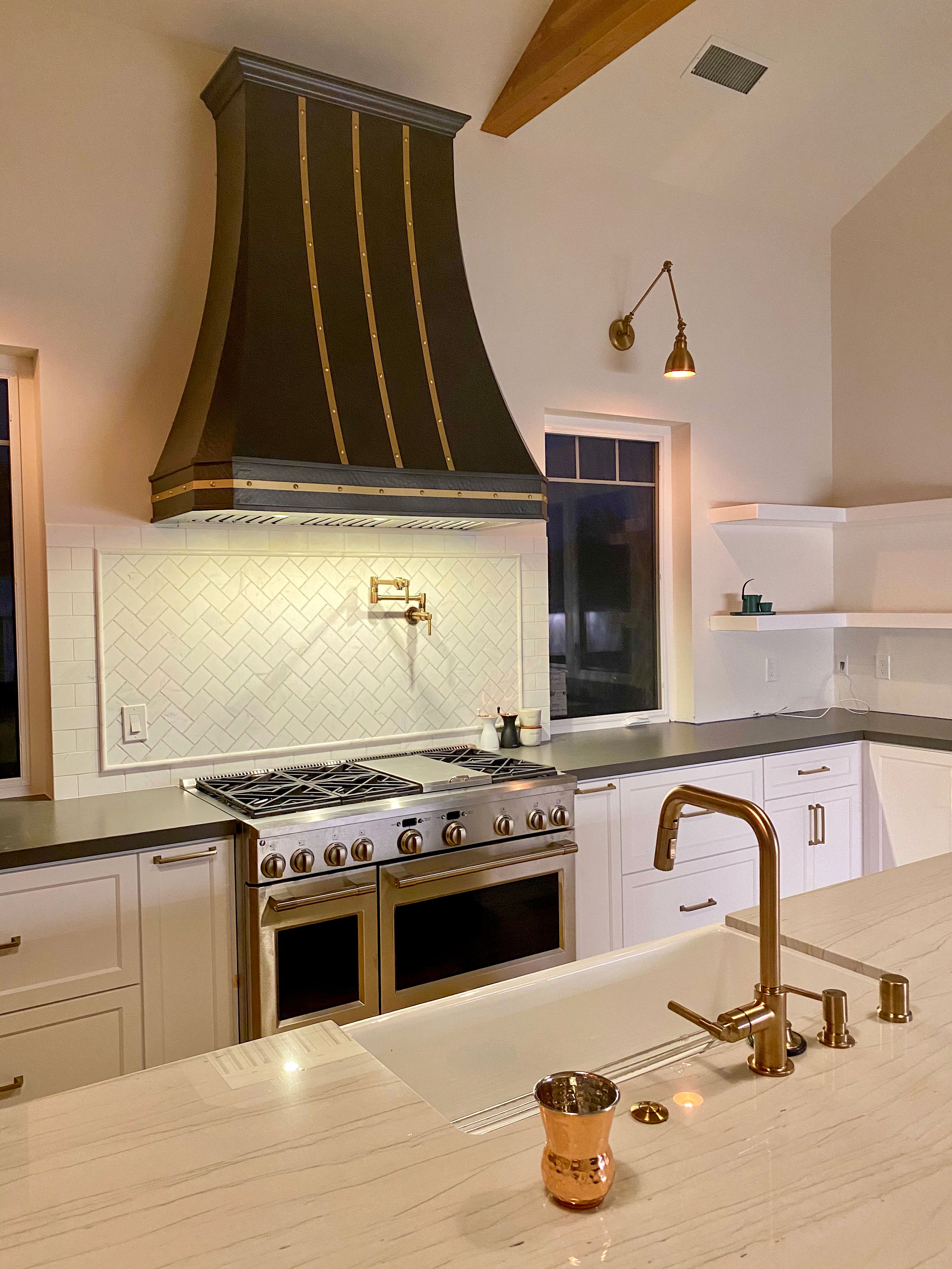 Embark with french kitchen design idea, featuring white cabinets, sleek grey kitchen countertops, captivating brick backsplash with range hood