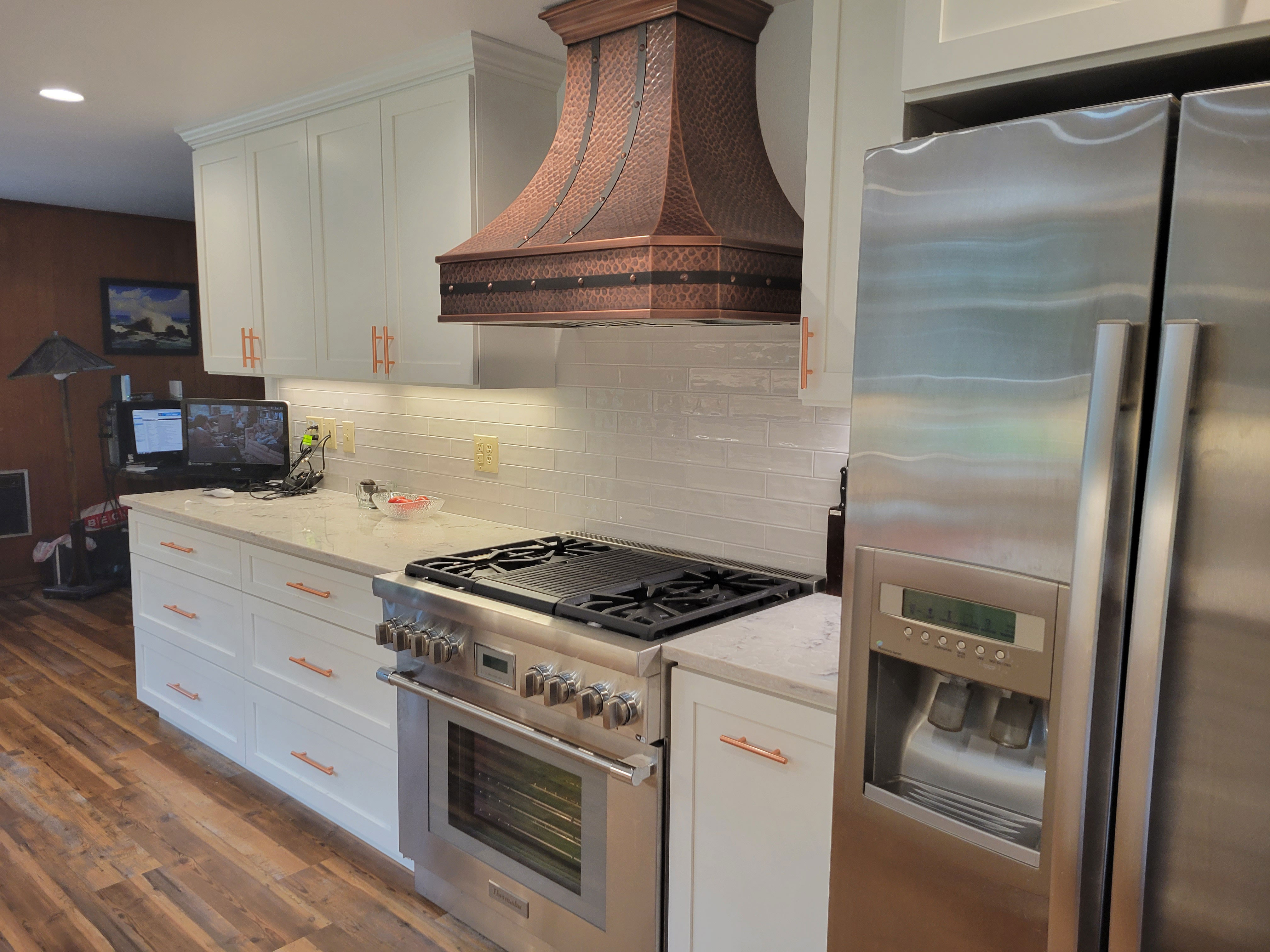 Classic kitchen design with white kitchen cabinets, marble kitchen countertops with range hood stylish brick backsplash