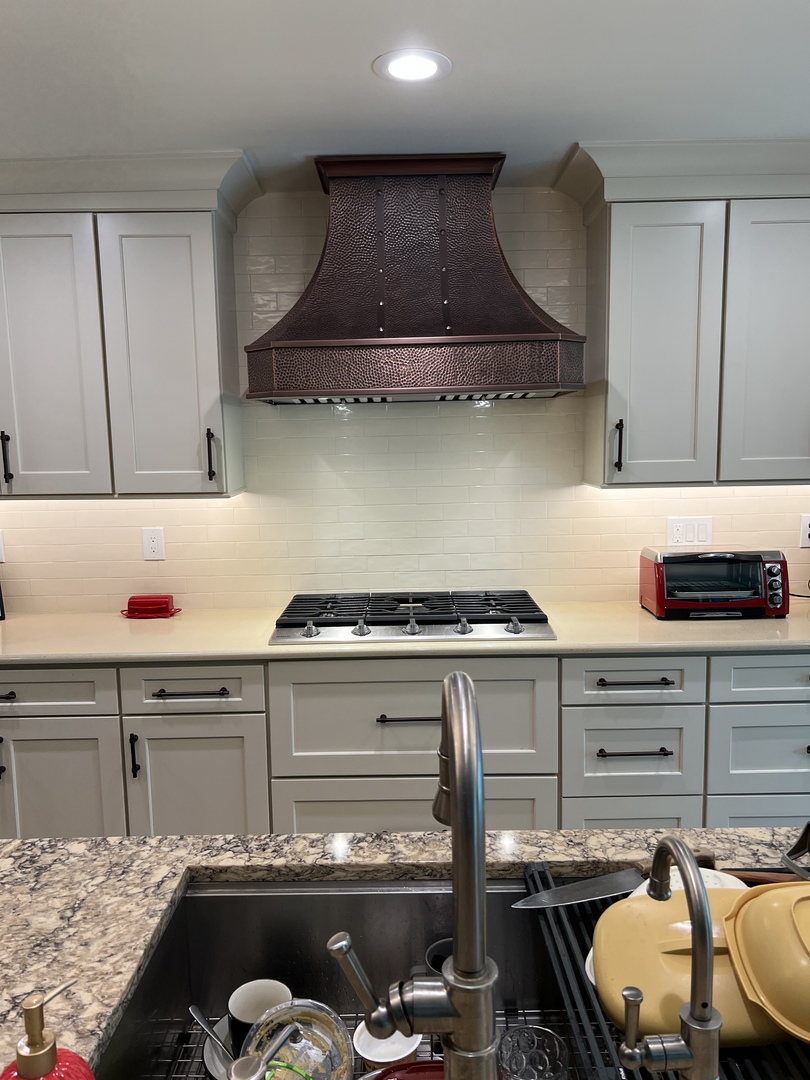 Kitchen design with range hood, grey cabinets,marble countertops captivating brick backsplash