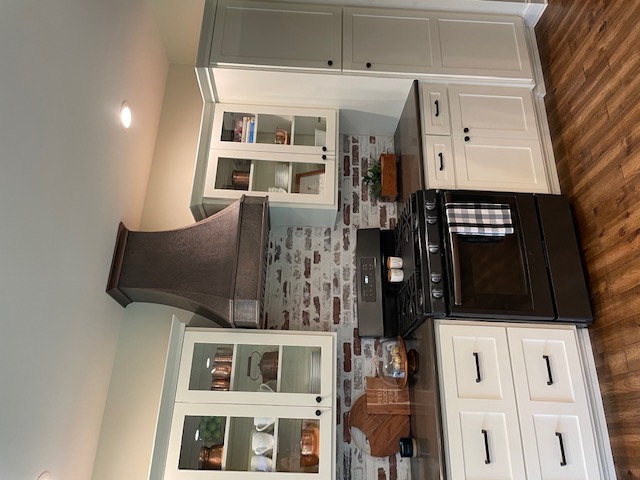 Classic white kitchen cabinets,kitchen design idea,range hood options and sleek black kitchen countertops,charming brick backsplash