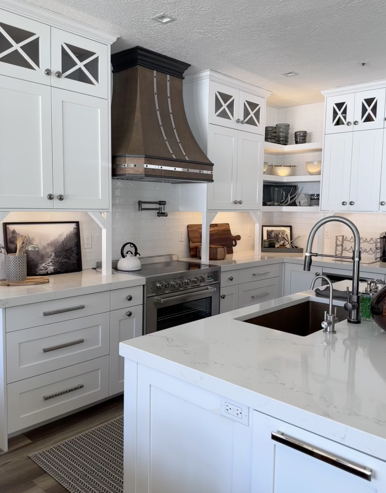 A classic kitchen design idea featuring white kitchen cabinets, white kitchen countertops, brick backsplash complemented by a copper range hood