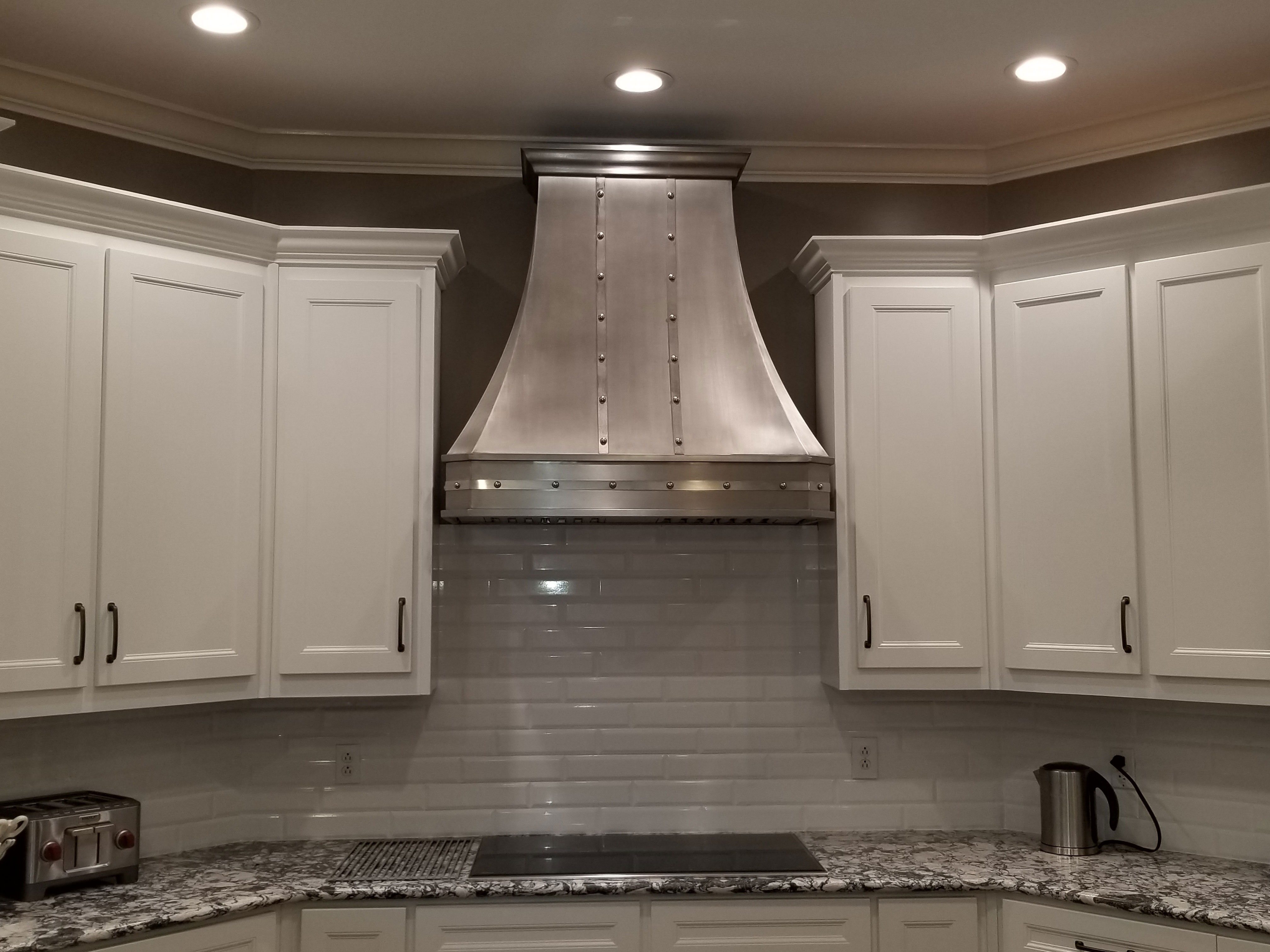 Stainless steel range hood with rivets and bands. World CopperSmith