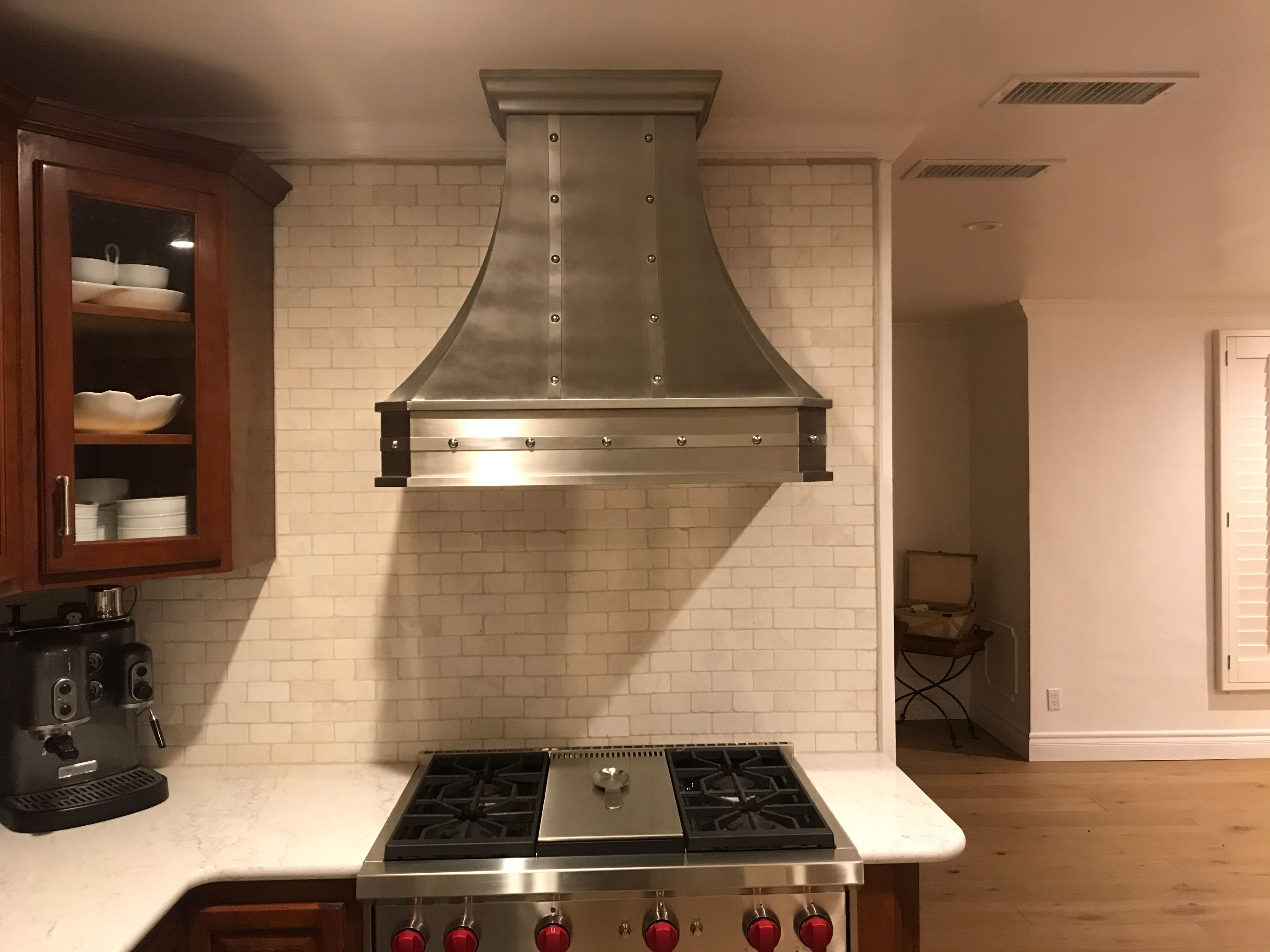 Kitchen design idea with range hood and rich brown kitchen cabinets, white kitchen countertops and brick backsplash
