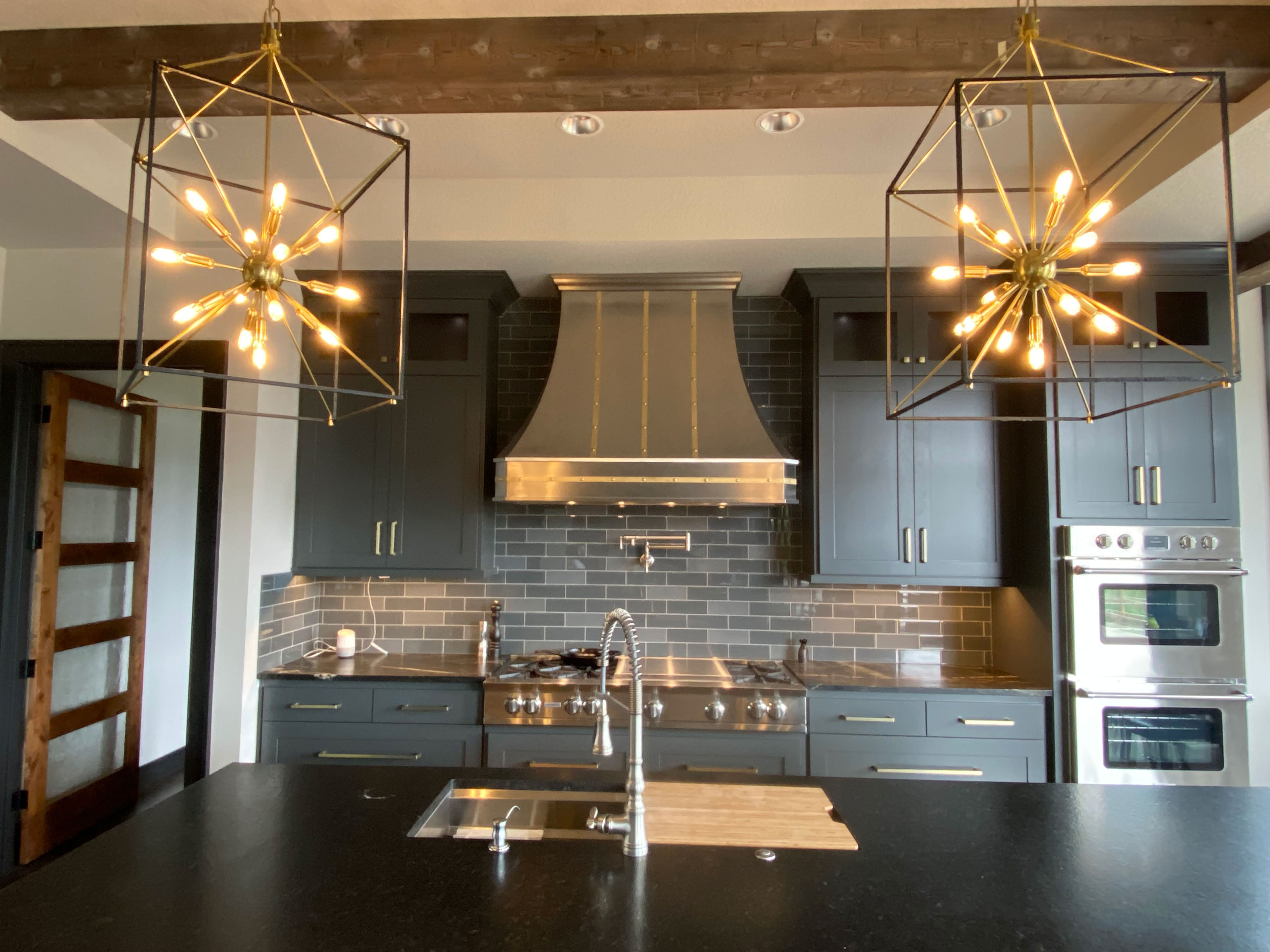 Stainless steel range hood with black and copper details in kitchen World CopperSmith