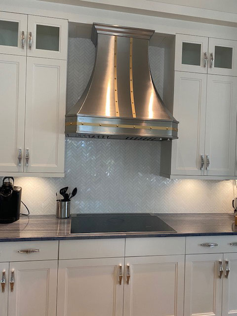 Stunning range hood and exquisite marble features such as countertops and backsplash, the french kitchen design brown kitchen cabinets