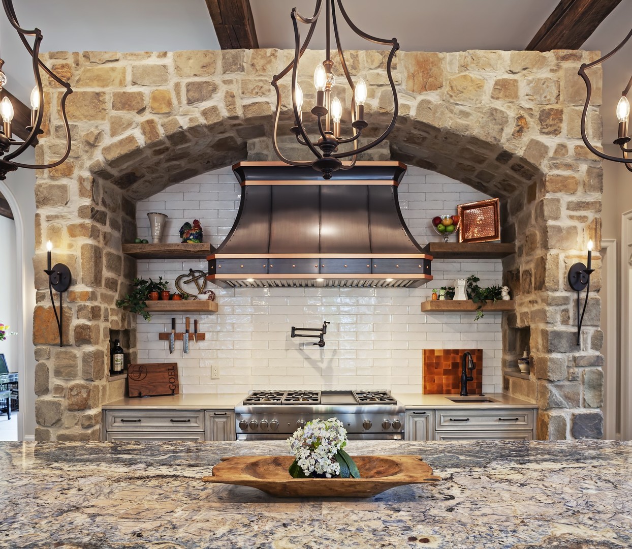 French kitchen design with range hood, white cabinets,marble countertops brick backsplash