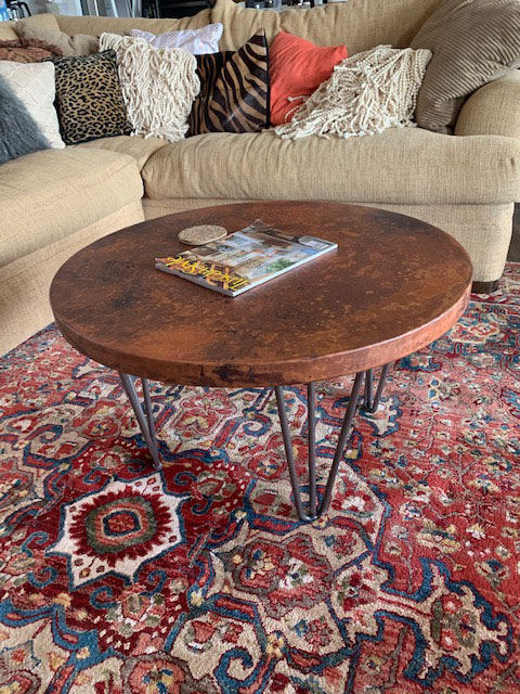 Two-toned copper coffee table in room with vibrant rug World CopperSmith