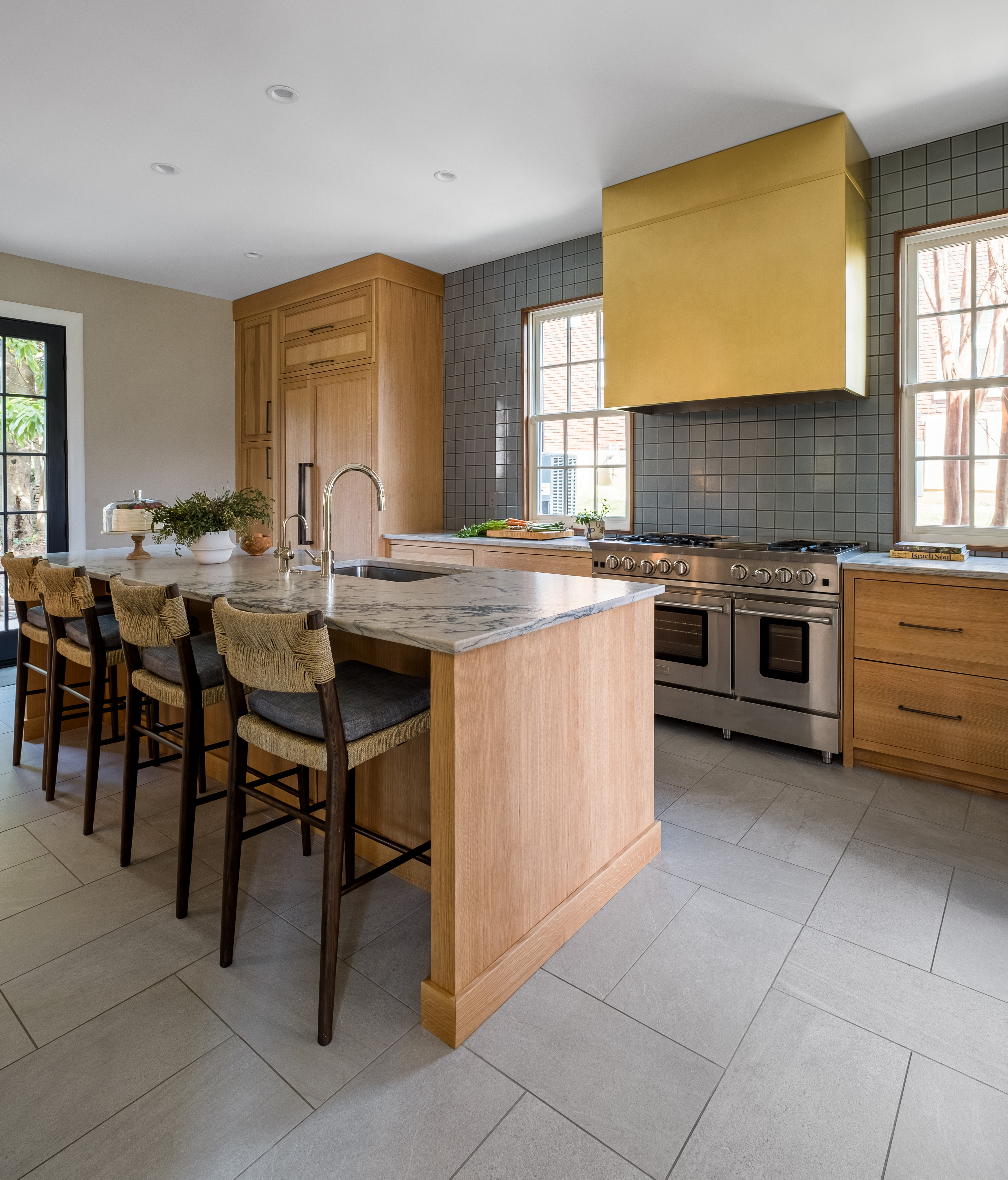 A modern french kitchen design with brown kitchen cabinets showcases exquisite marble kitchen countertops stunning marble backsplash