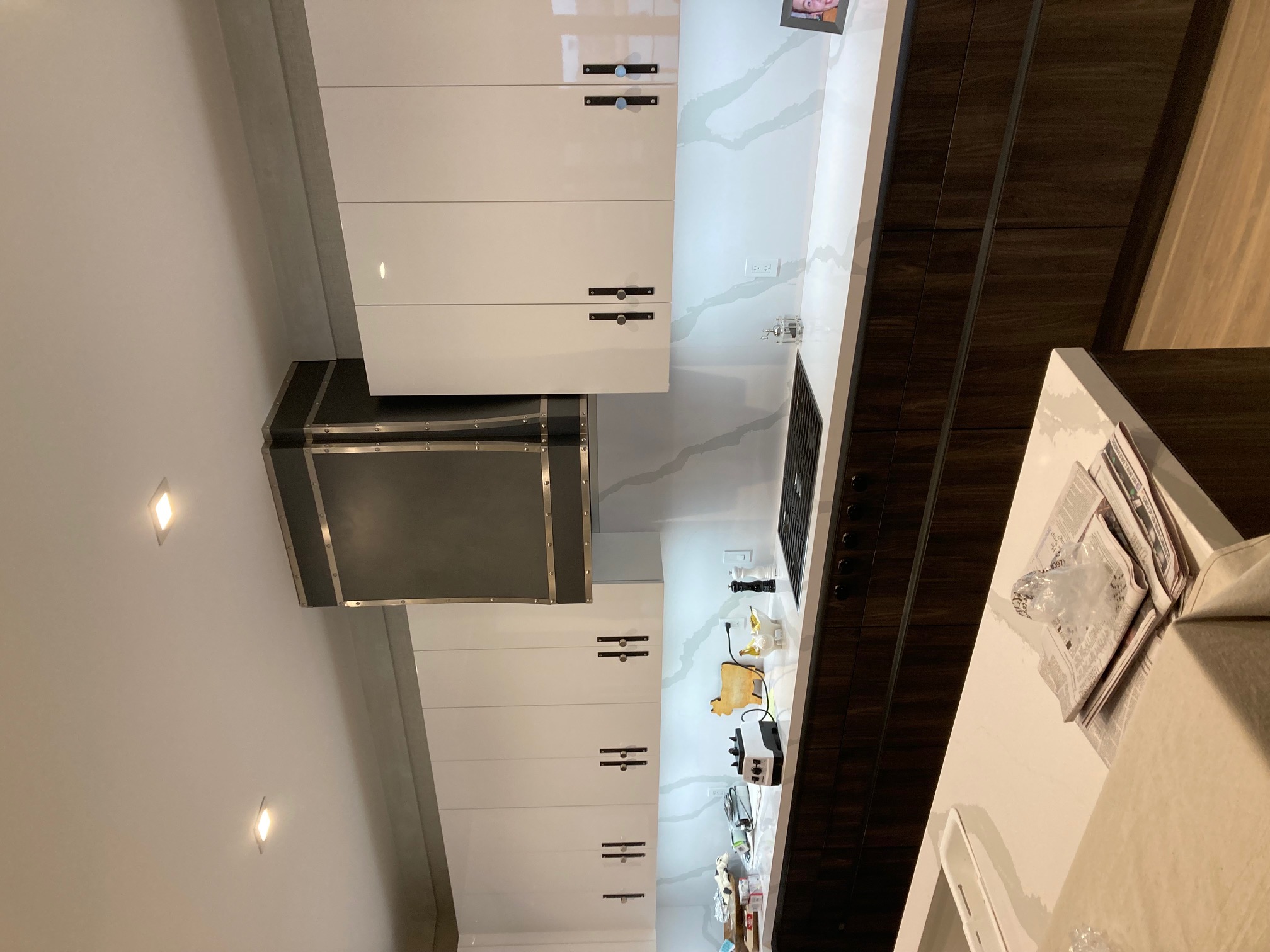 Coastal kitchen projects kitchen design idea with a variety of range hood options, white kitchen cabinets, pristine white kitchen countertops, marble backsplash