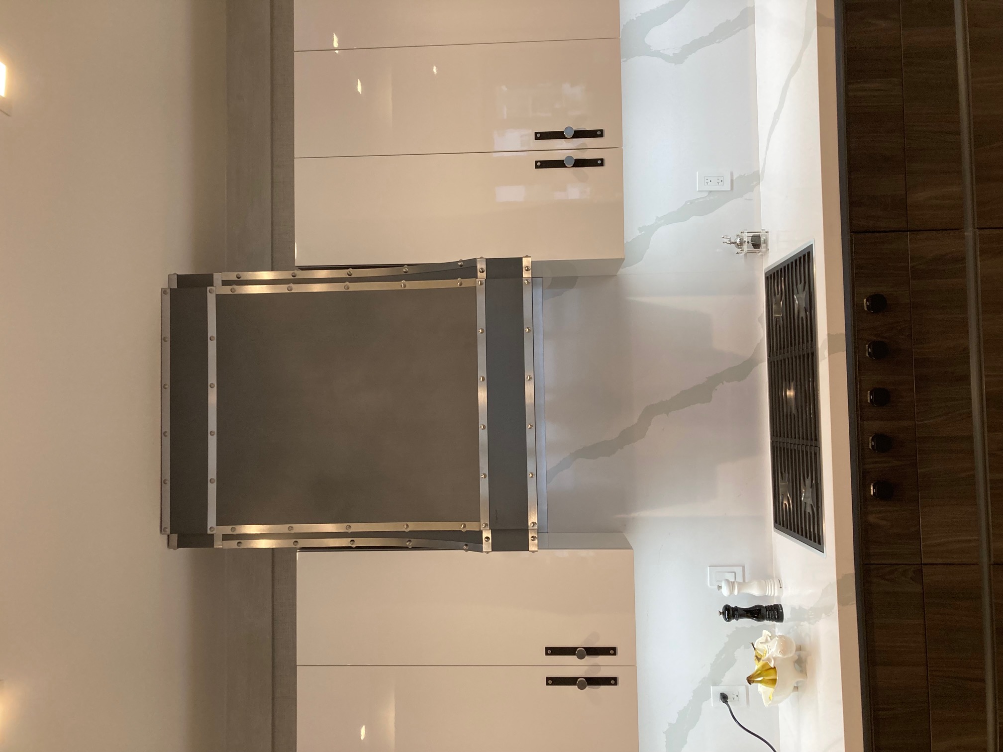 Rustic kitchen inspiration with a range of hood idea, charming white kitchen cabinets, elegant white kitchen countertops, marble backsplash