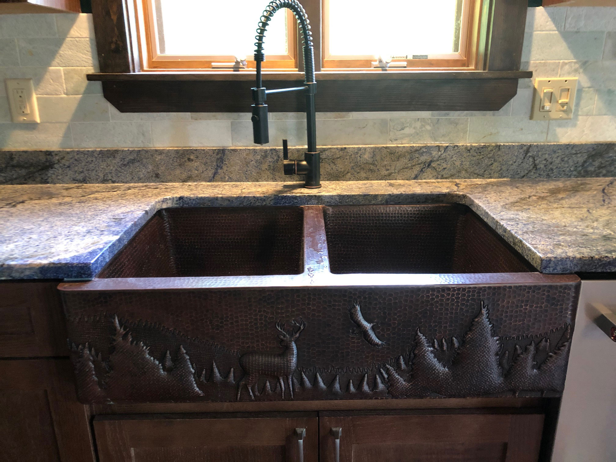 Kitchen design idea with beautiful sink idea, brown kitchen cabinets, marble kitchen countertops and brick backsplash