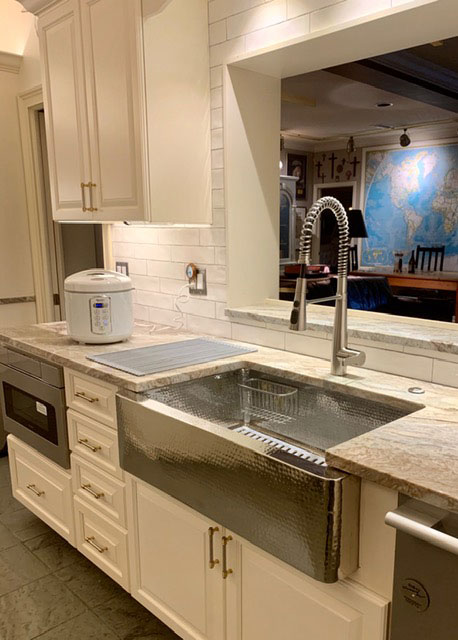 Stainless steel apron sink with hammered pattern in white cabinets World CopperSmith