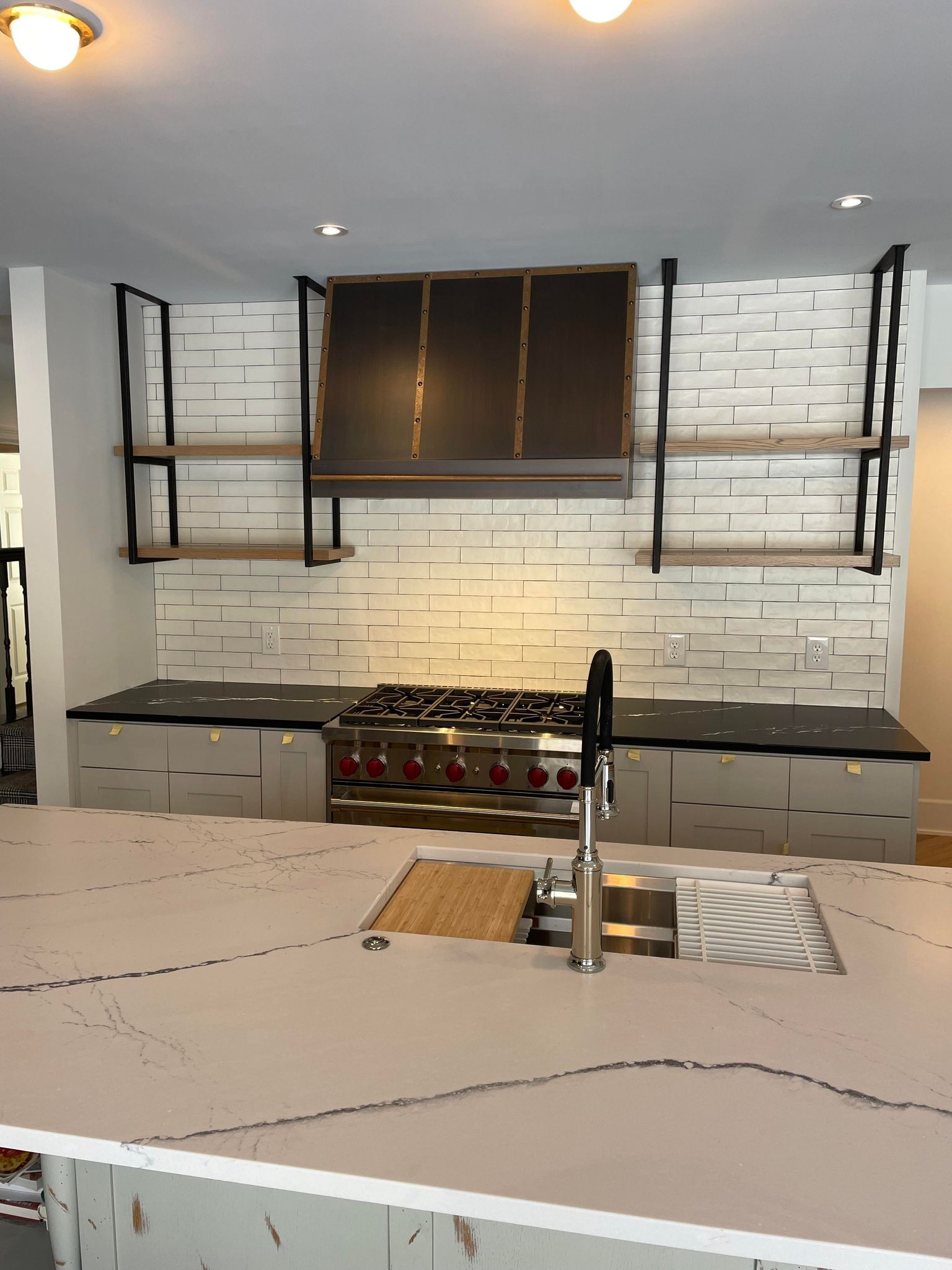 A rustic brick backsplash, kitchen design idea, french-inspired elegant white kitchen cabinets, exquisite marble kitchen countertops, and kitchen table idea