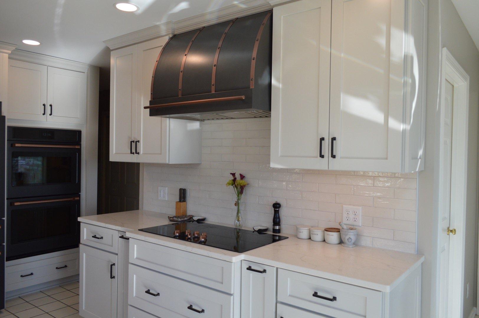 Amazing cottage kitchen with white kitchen cabinets, white kitchen countertops, brick backsplash, complemented by a stylish range hood