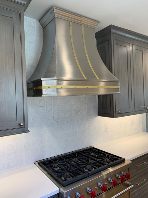 Tuscan kitchen design idea featuring a range hood, grey kitchen cabinets, white kitchen countertops, charming brick backsplash