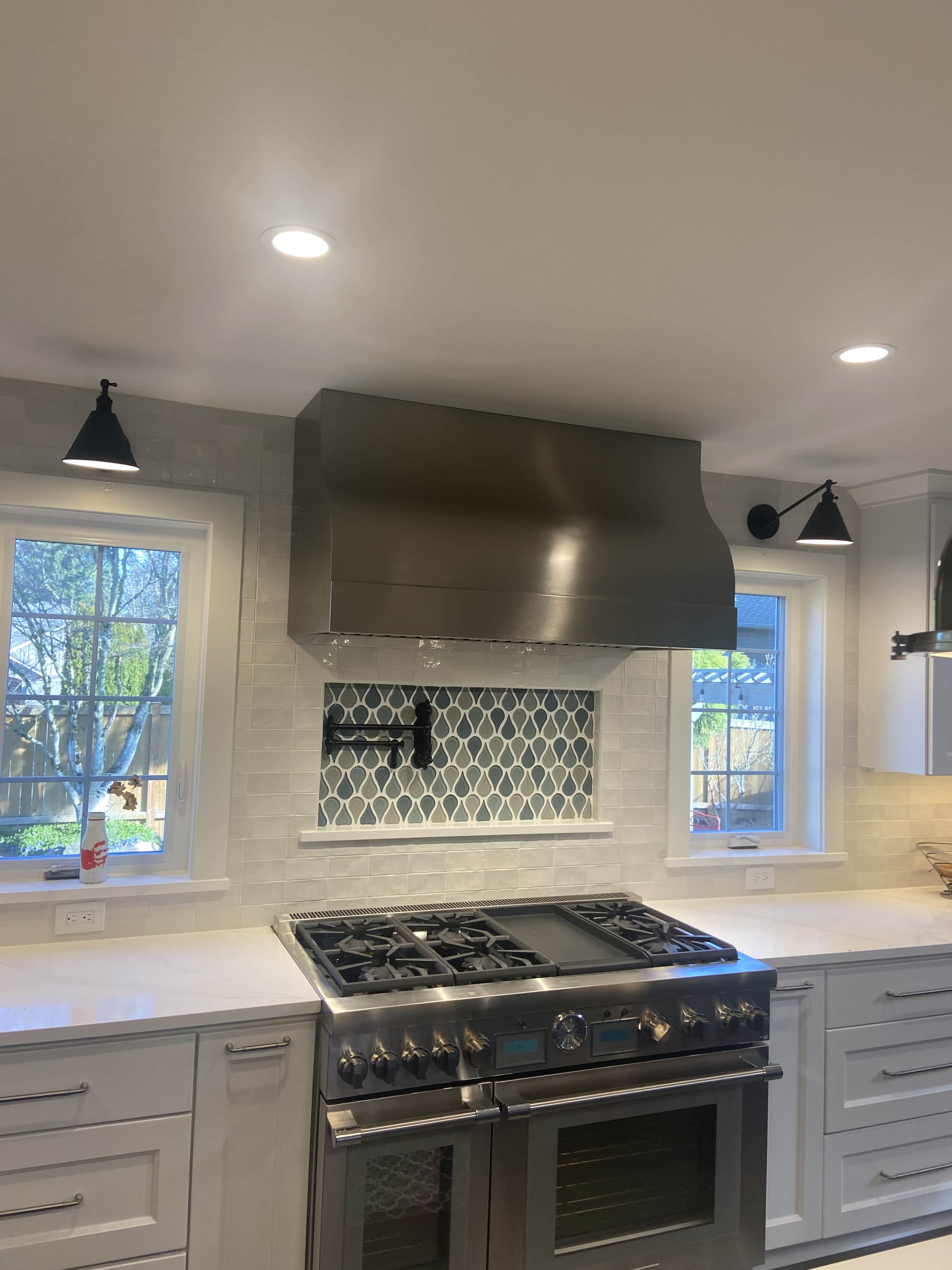 Contemporary kitchen remodeling project, sleek white kitchen cabinets and white kitchen countertops, accentuated by a stylish brick backsplash