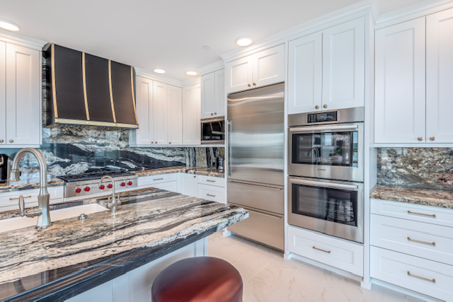 Cozy country kitchen design featuring white kitchen cabinets, luxurious marble kitchen countertops, and white tile backsplash, creative kitchen sink idea