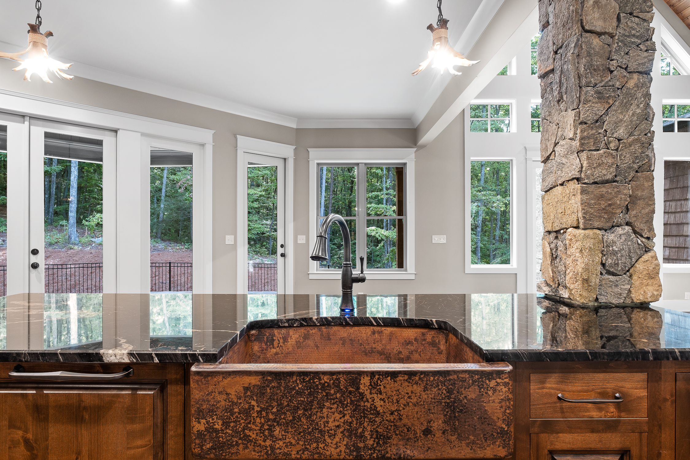 Copper recessed kitchen sink with black granite countertop and glass windows World CopperSmith