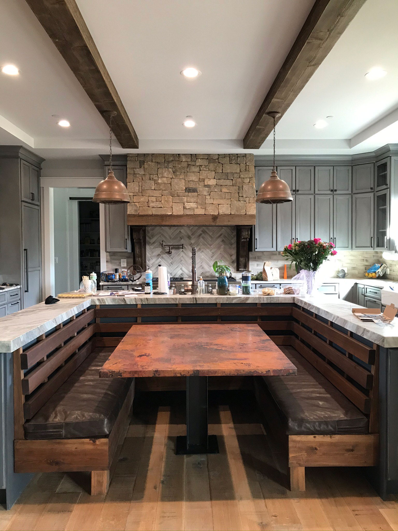 Mind-blowing tuscan kitchen with white cabinets, marble countertops, brick backsplash, the focal point is a sleek range hood